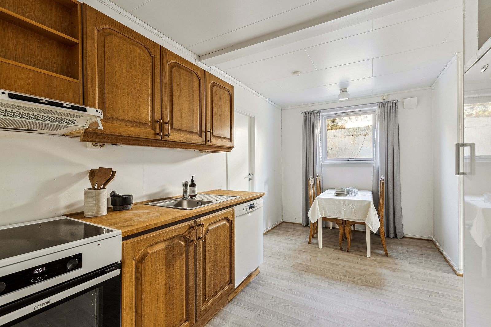 Eldre kjøkken, men fullt funksjonelt. Kjøkkenet har nisjer med opplegg og plass til komfyr, kjøleskap og oppvaskmaskin, samt mekanisk avtrekk over kokeplassen med utkast til vegg. Galleribilde