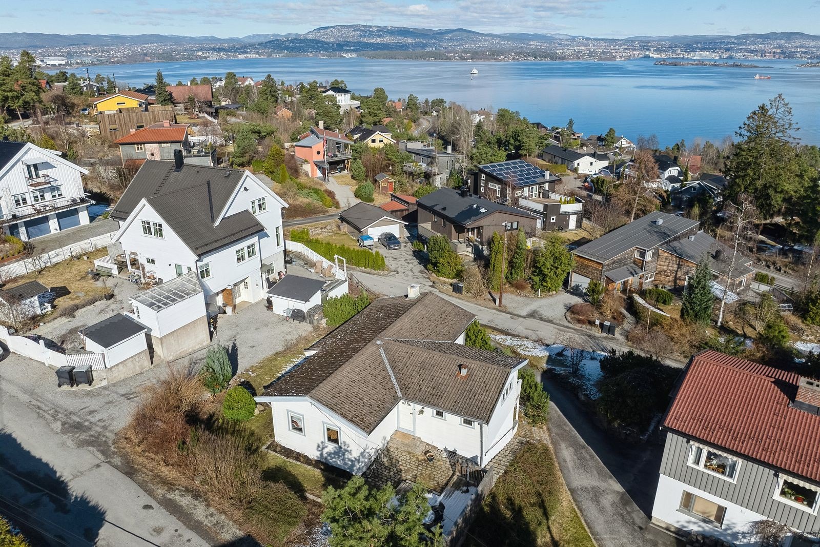 Her er det rikelig plass til både en stor sofagruppe og et spisebord, noe som gjør det til et ideelt rom for både avslapning og sosialt samvær. Galleribilde