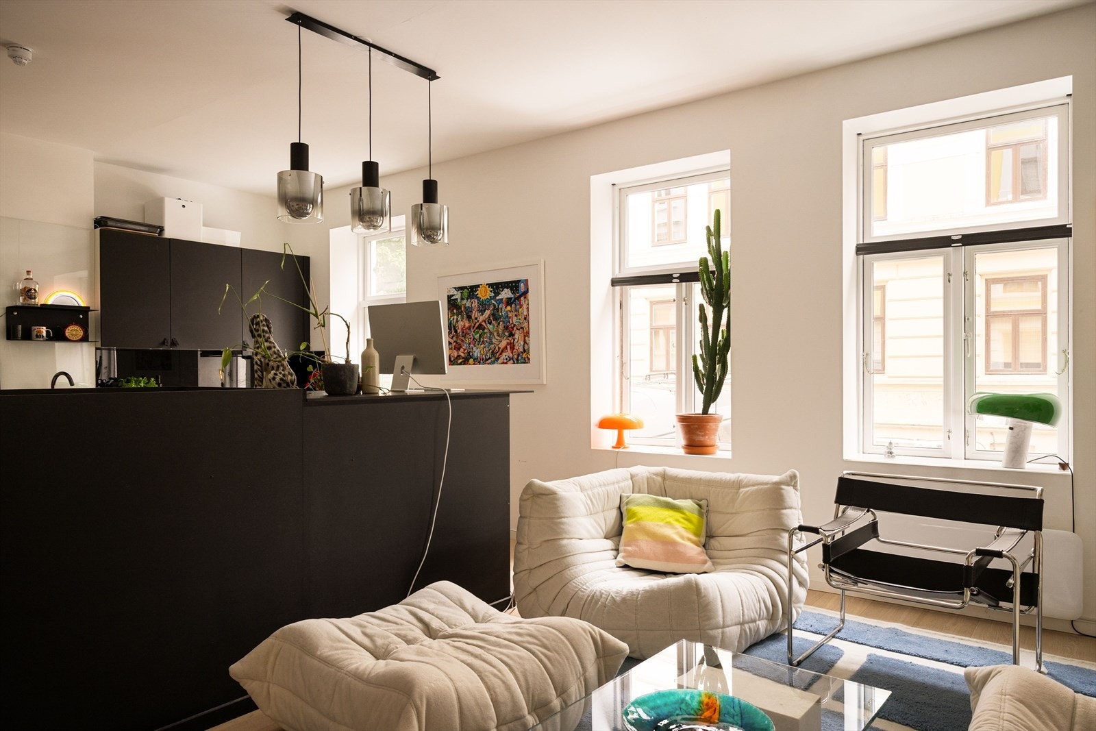 Trappen ned til underetasjen er plassert midt i rommet, og skaper et naturlig skille mellom kjøkken og stue i tillegg til å åpne opp for flere møbleringsmuligheter. Barløsning/kontorstasjon på enden av trappen. Galleribilde