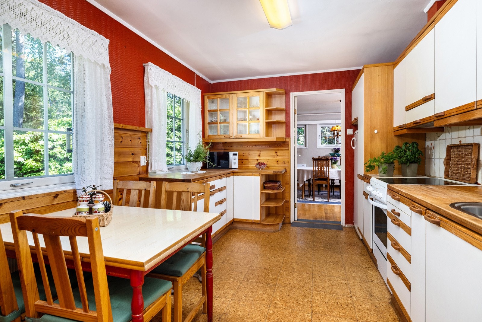 Eldre kjøkken med heltre benkeplate og kombinasjon av hvite og trefargede fronter. Galleribilde