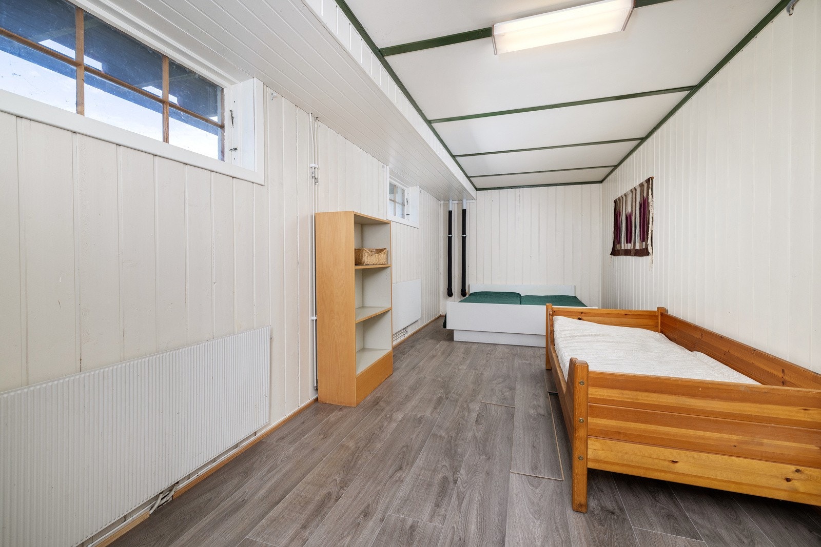 Kjellerstue med ekstra oppholdsrom for familie eller ungdom. Rommet blir brukt som soverom for gjester. Galleribilde