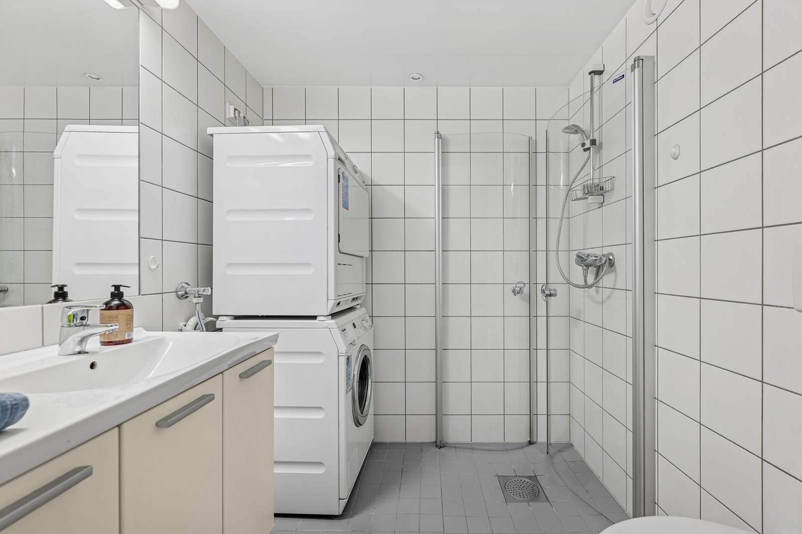Badet er utstyrt med vegghengt wc, servant med underskap, innfliset speil med overlys, veggskap, inn-/utadslående dusjdør og opplegg for vaskemaskin. Galleribilde