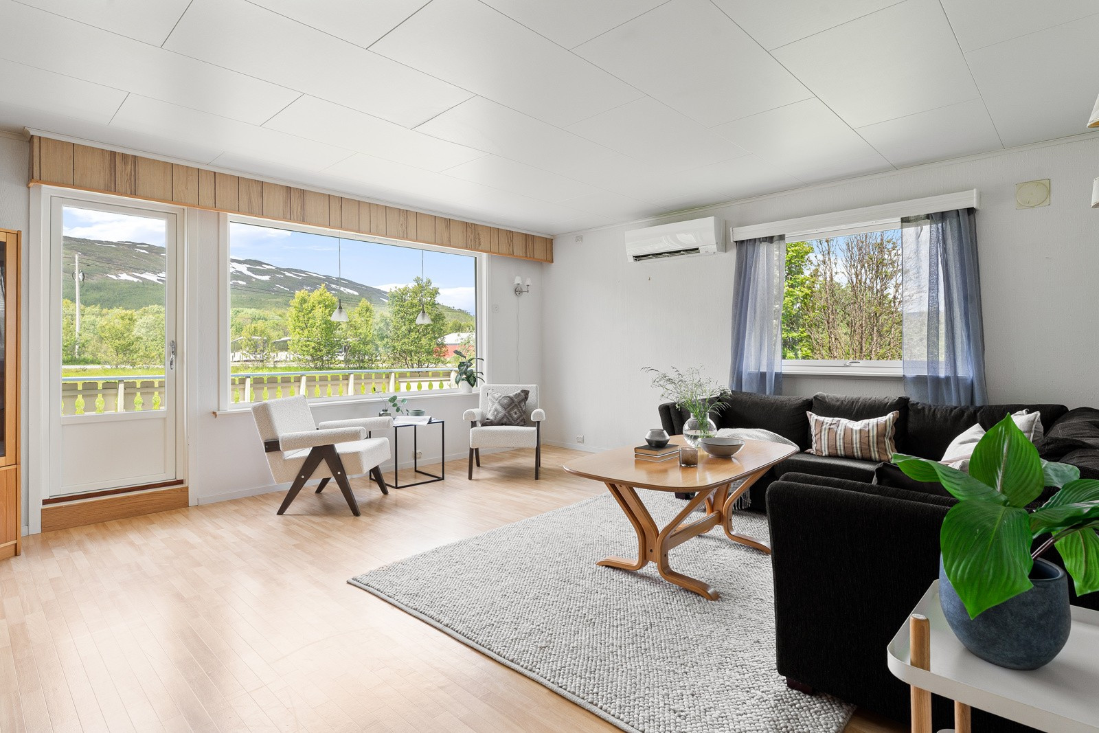 Lys og romslig stue med store vindusflater i tre himmelretninger, som gir gode lysforhold.