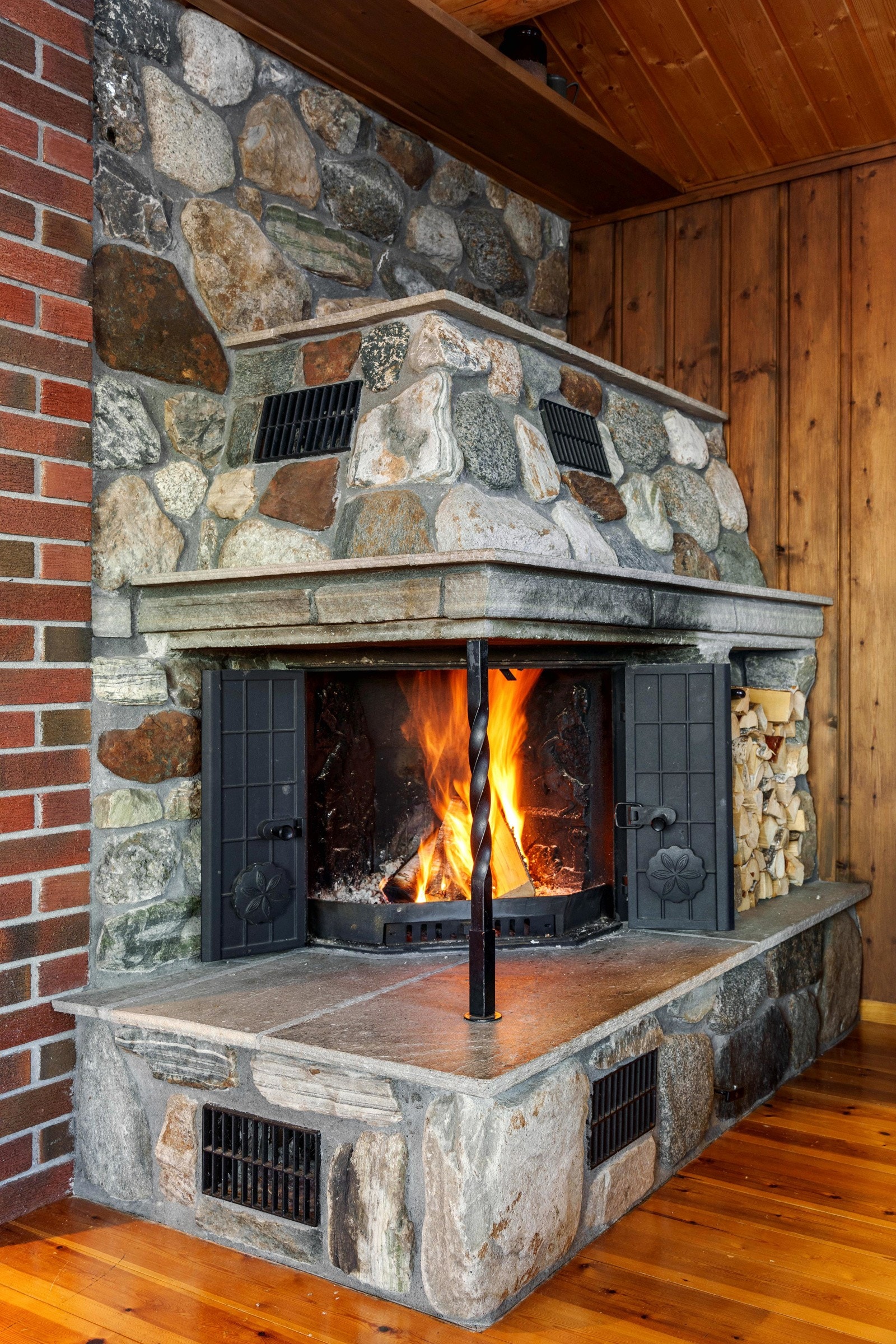 Midtpunktet i stuen er den flotte peisinnsatsen utført med tegl og naturstein, peisen varmer effektivt opp hytta og skaper en lun atmosfære i rommet. Galleribilde