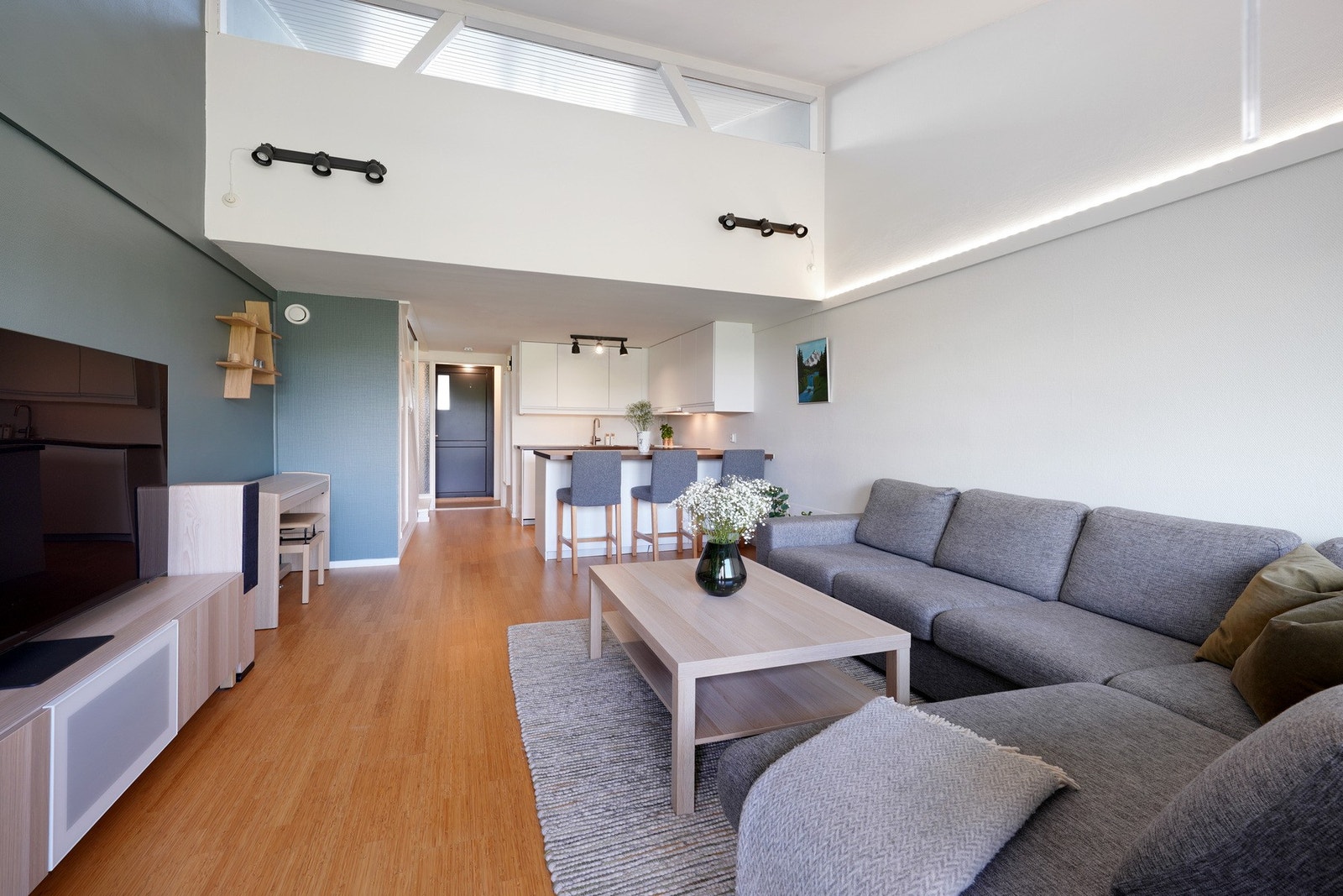 Åpen løsning med sittegruppe og barstoler ved kjøkkenbenken. Galleribilde