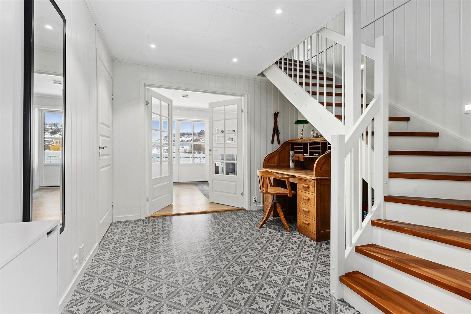 Romslig entré med doble dører inn til stua. Boligen har gulvvarme i hele 1. etasje, unntatt på soverom Galleribilde