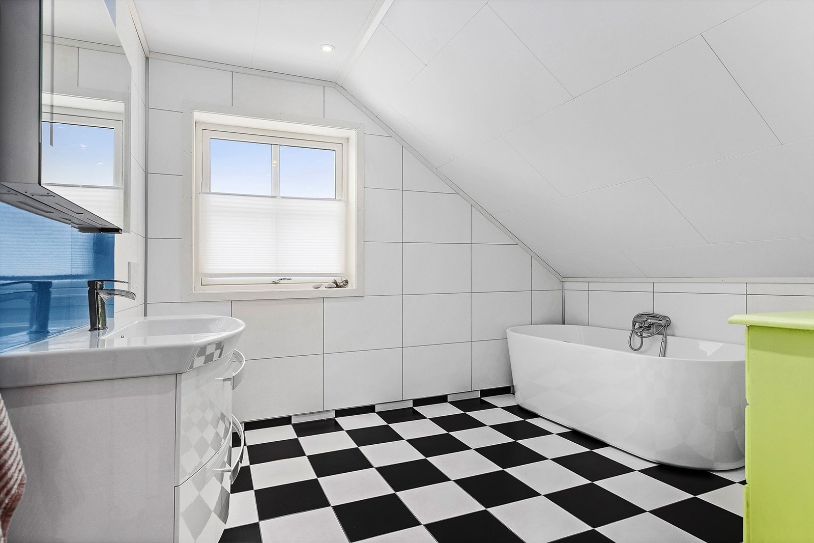 Bad på loftet har badekar, vegghengt toalett og innredning med servant Galleribilde