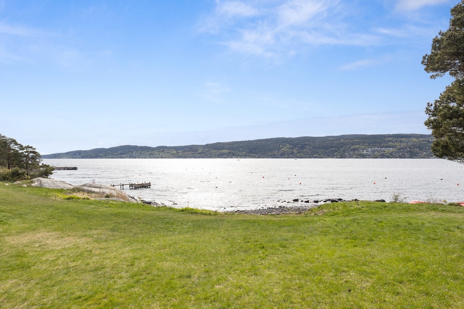 Trivelig område med gresslette, sandstrand og svaberg Galleribilde