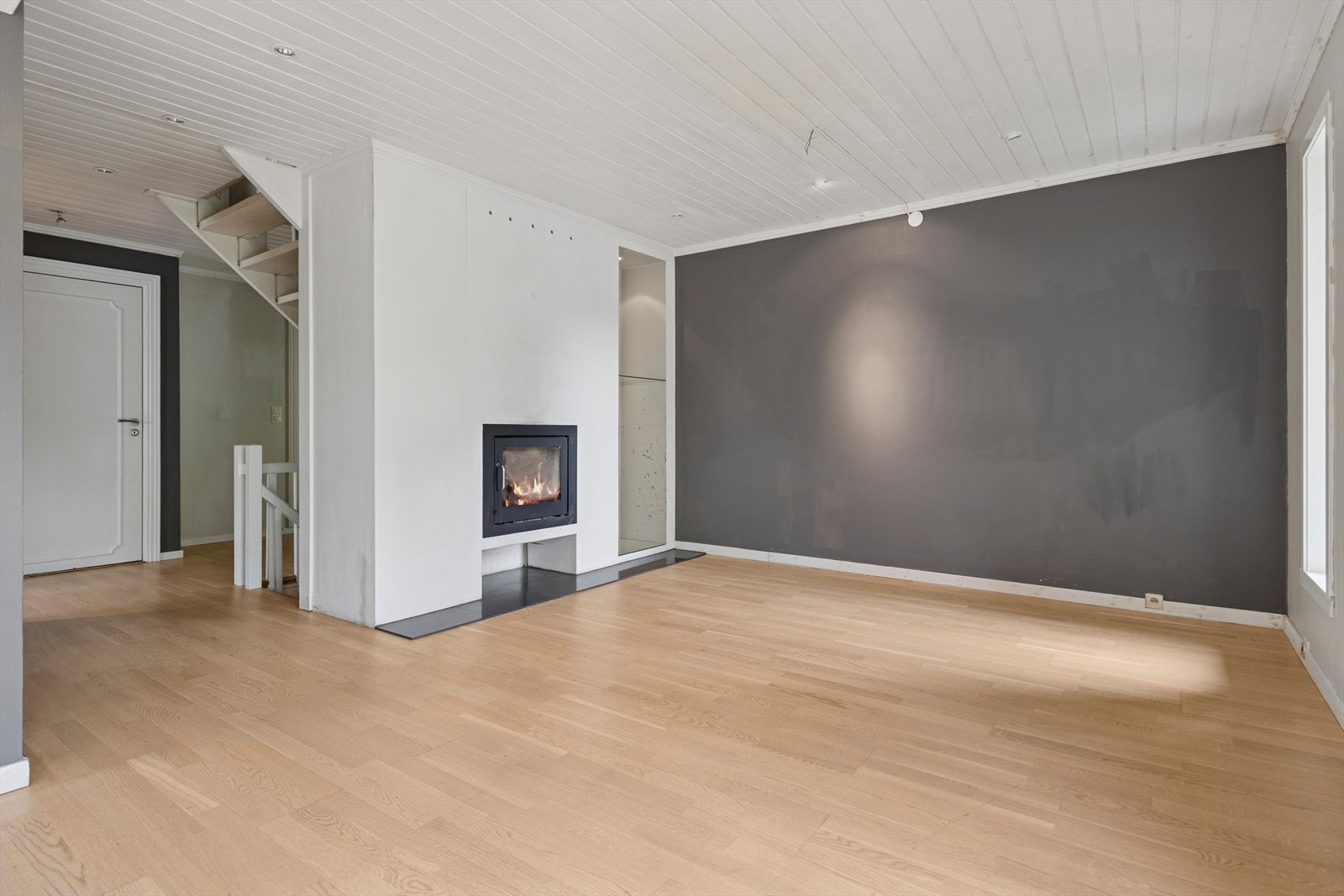 Det lyse gulvet gir rommet en varm og innbydende atmosfære, mens det hvitmalte paneltaket med downlights skaper en stilren og moderne følelse. Nøytrale farger på veggene gir gode muligheter for å sette sitt eget preg på innredningen. Galleribilde