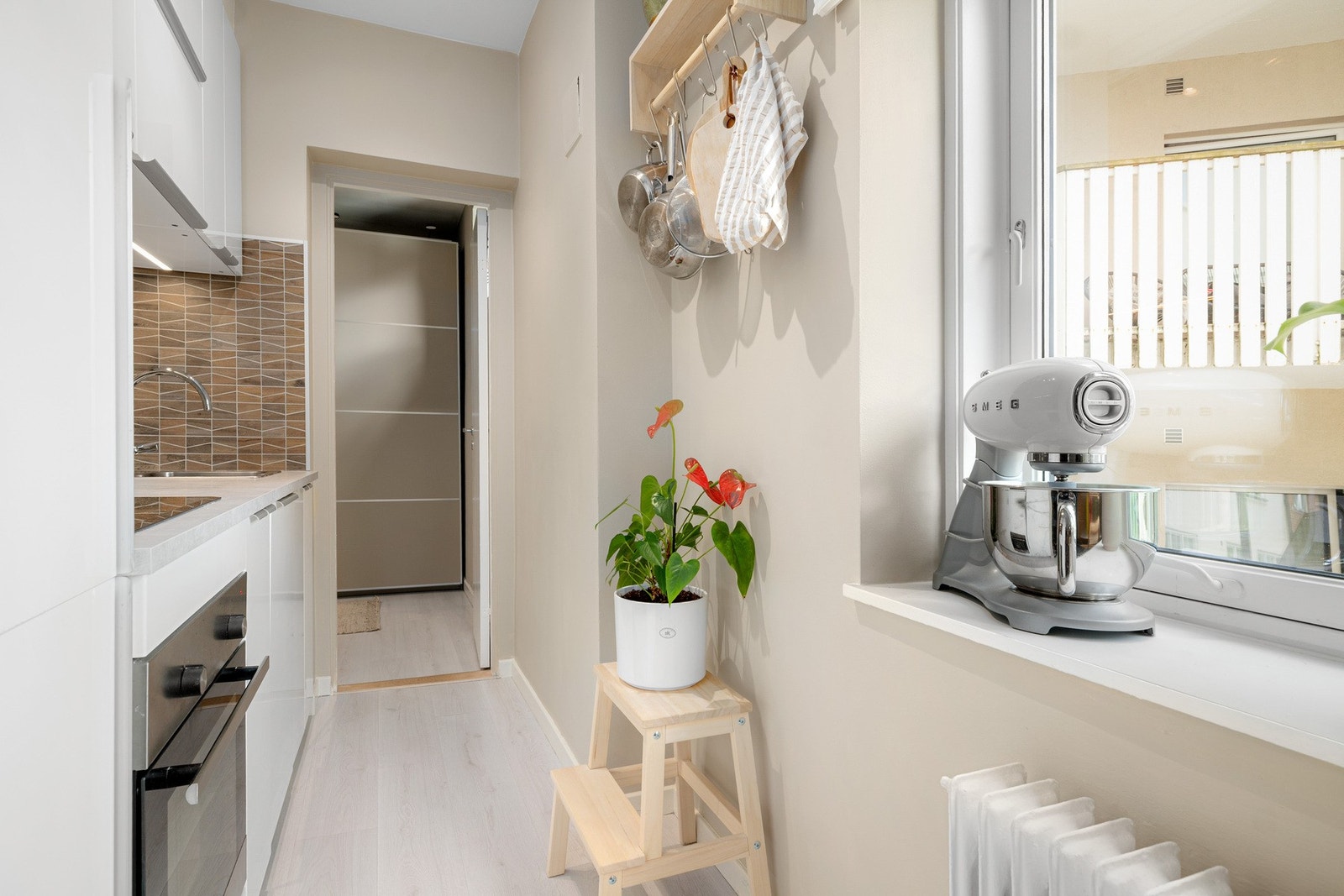 Planløsningen utnytter plassen godt, med både skap og arbeidsflater som gir praktisk oppbevaring og funksjonalitet. Galleribilde