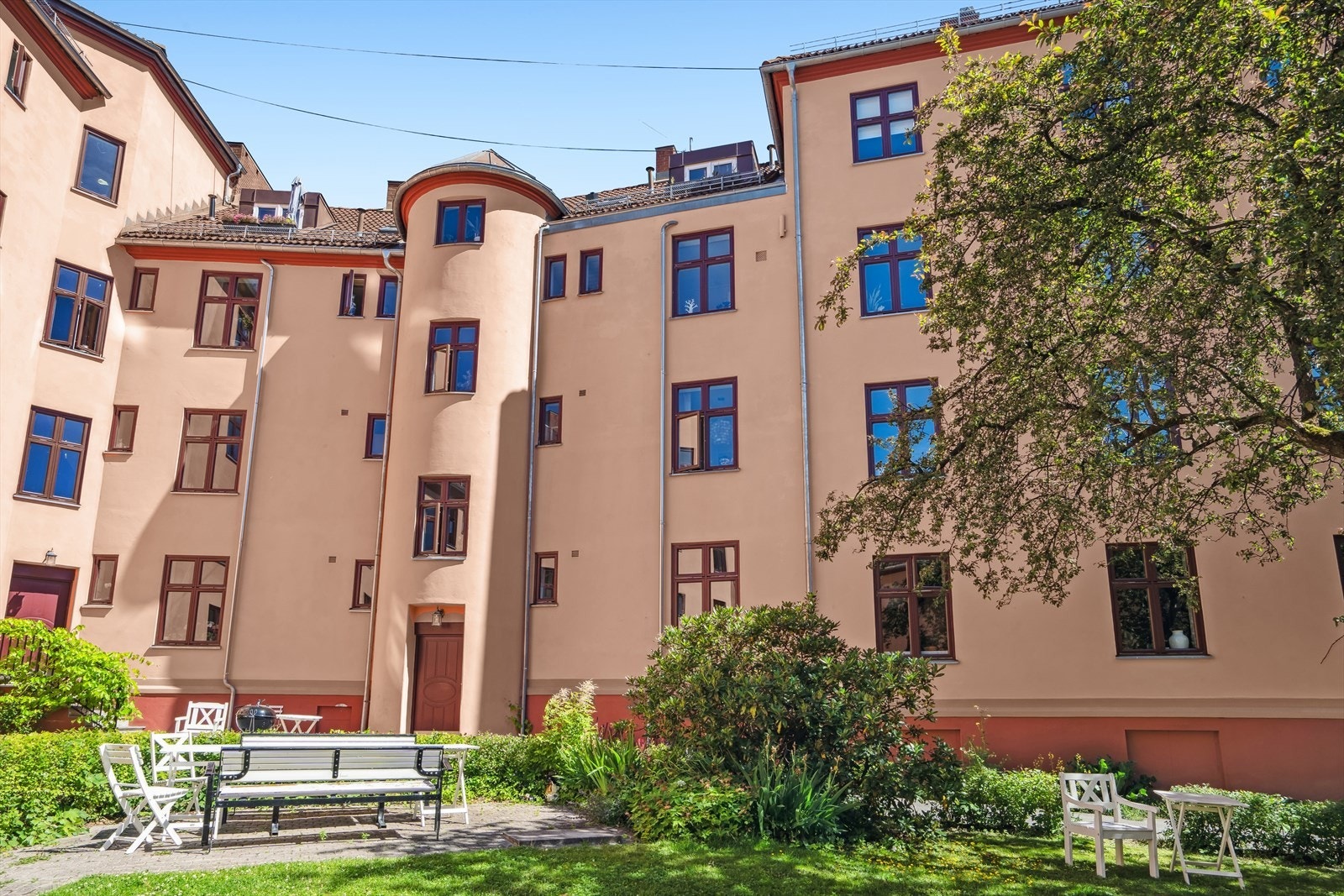 Idyllisk bakgård med sitteplasser, lekeapparater og grill - her ligger alt til rette for hyggelige sammenkomster. Galleribilde