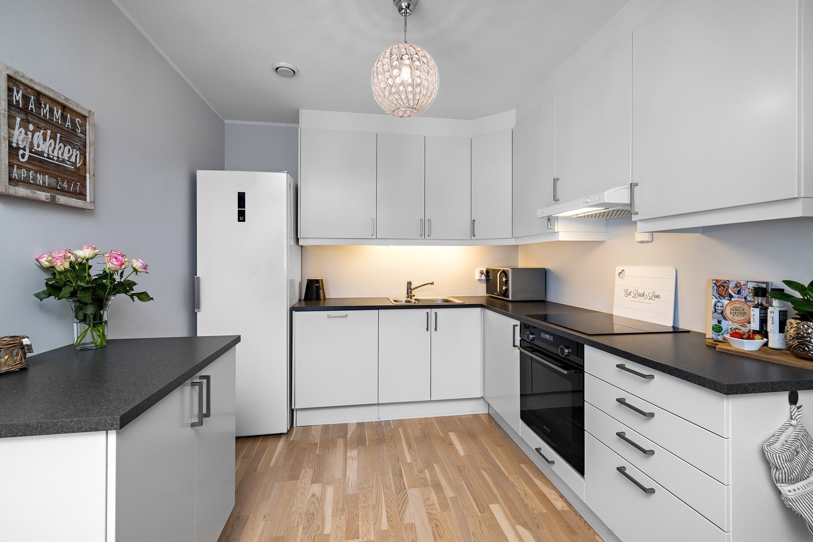 Kjøkkeninnredning med takhøye overskap, laminerte skrog, glatte fronter og laminert benkeplate. Godt med skap og benkeplass. Galleribilde