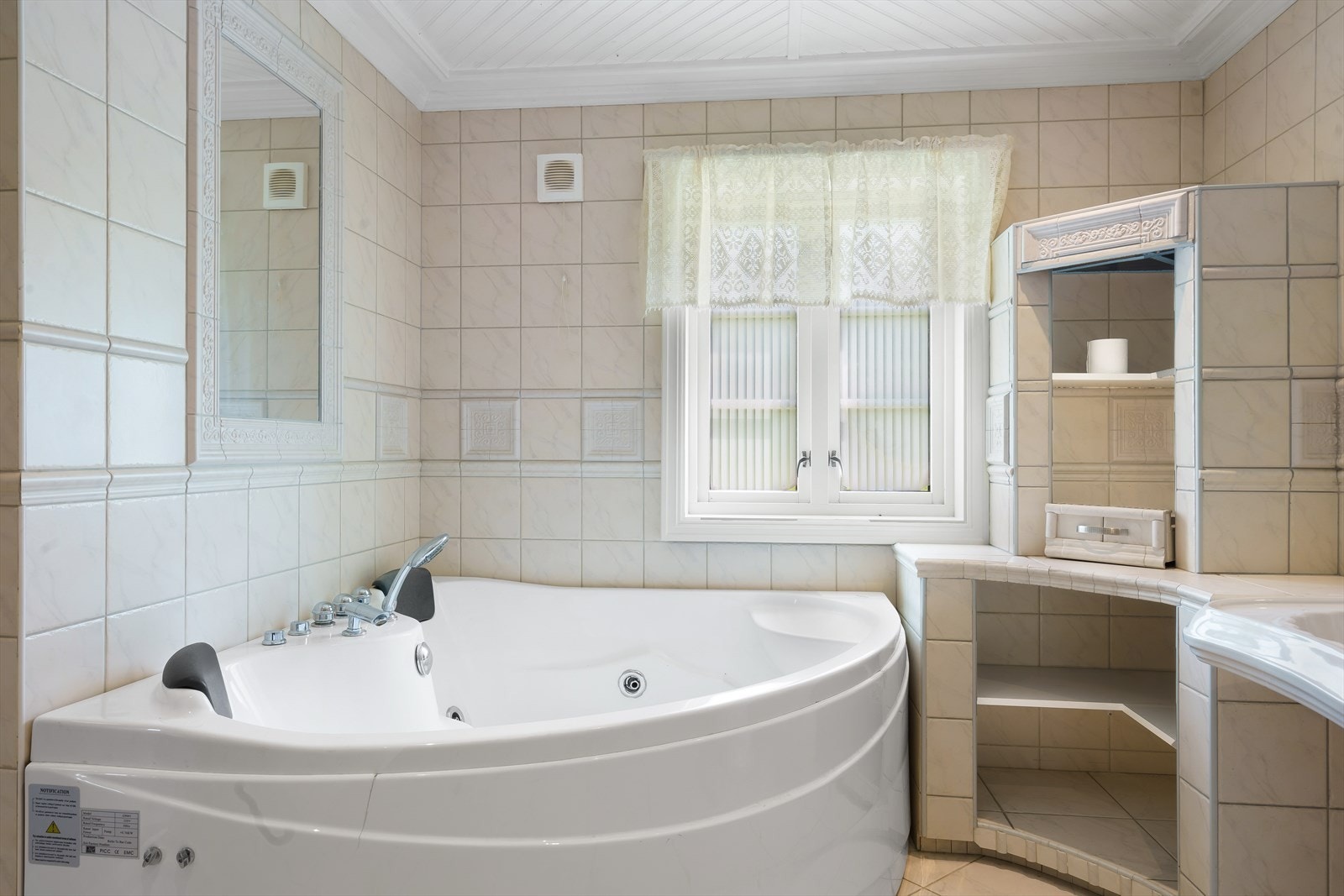 Badet er romslig og inneholder dusjkabinett, hjørne-boblebadekar med integrert speil i vegg, bidé og toalett. Galleribilde