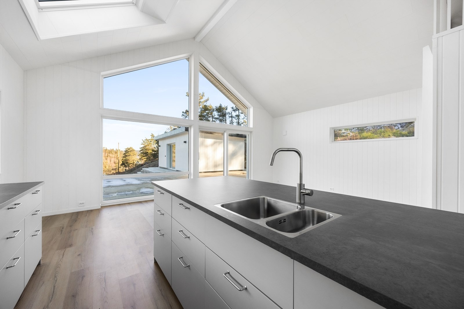 Kjøkkenøyen inneholder laminat benkeplate med dobbel nedfelt oppvaskkum og rikelig med oppbevaring. Galleribilde