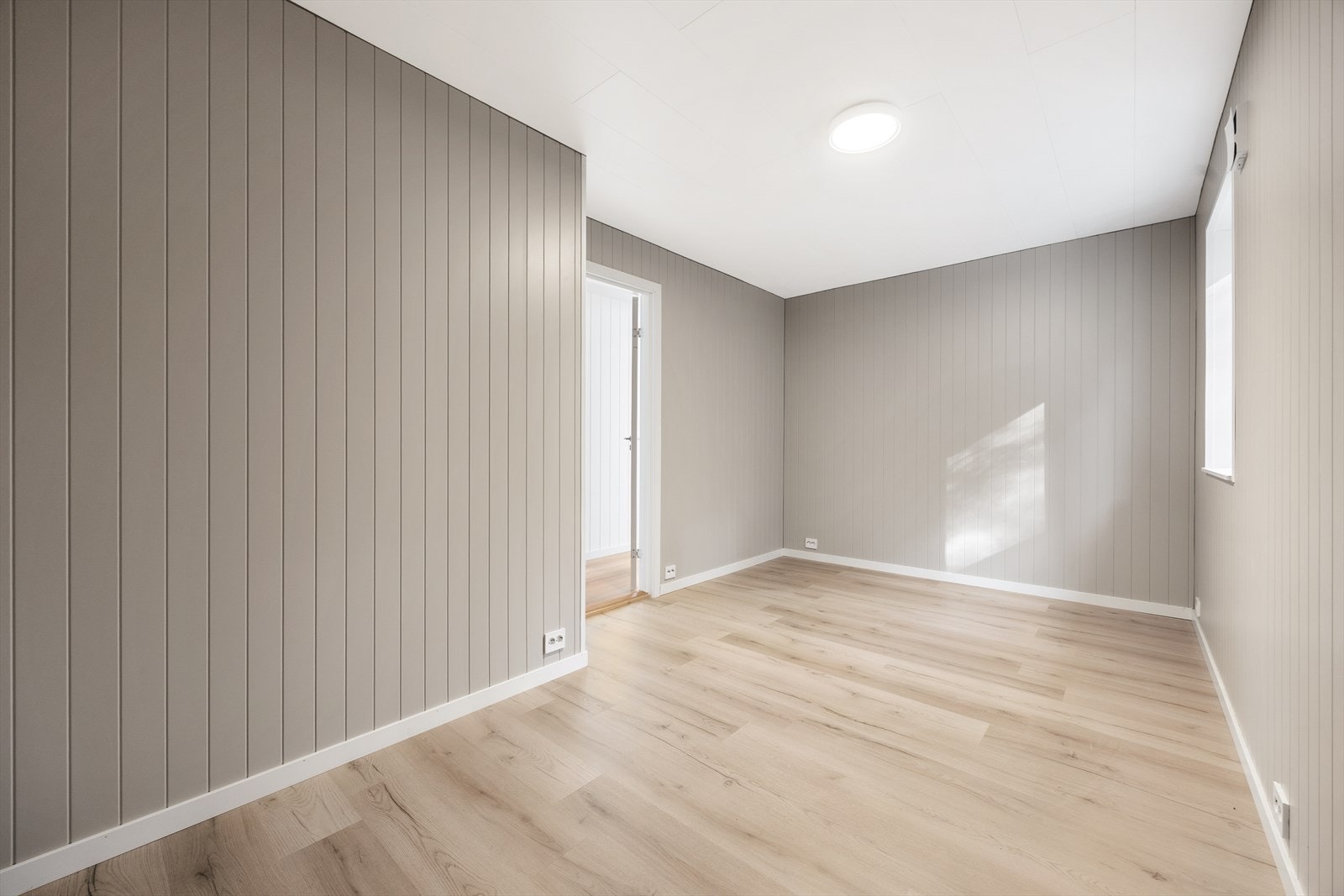 Gråmalte panel gir rommet en behagelig følelse. Galleribilde