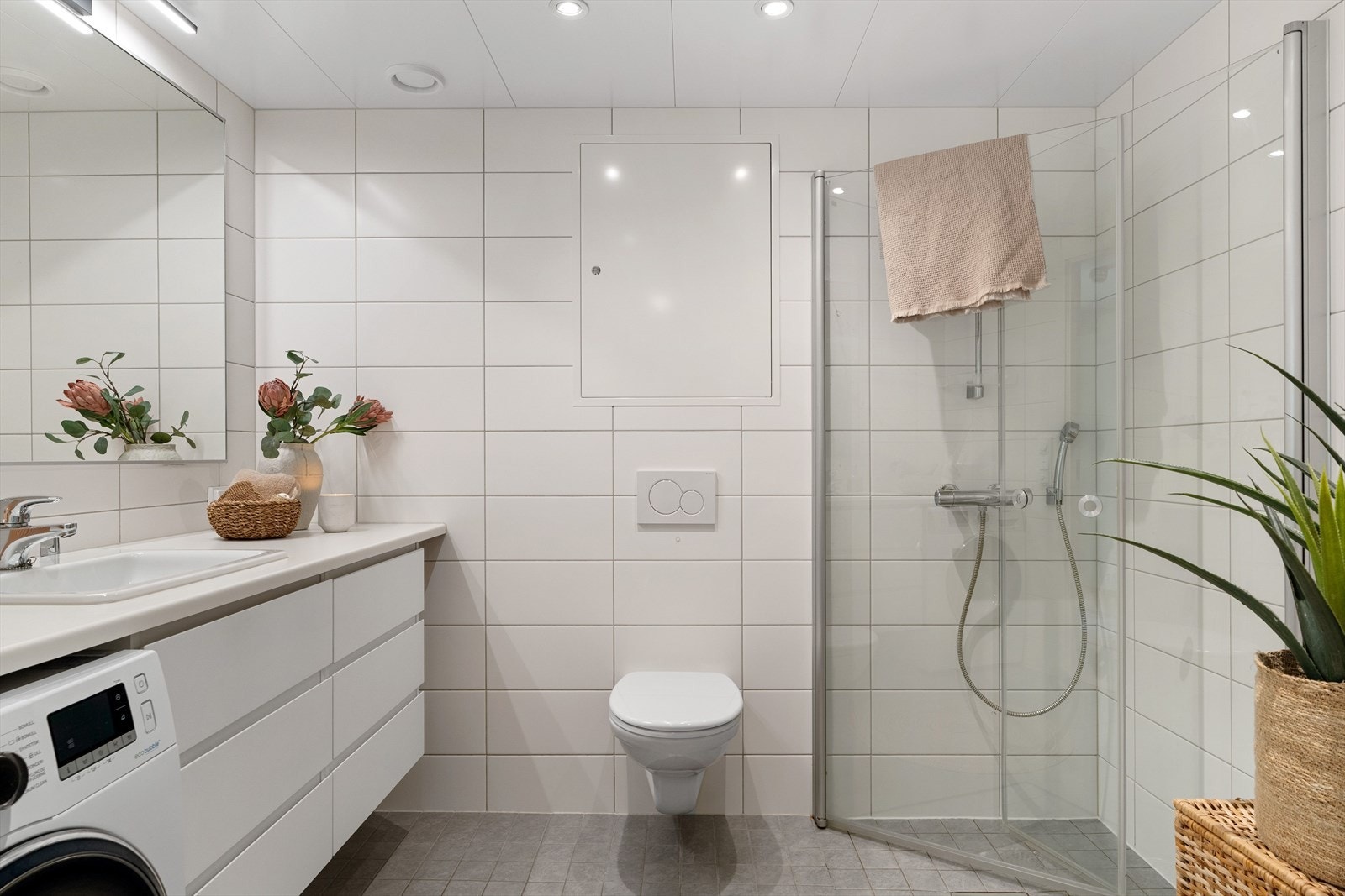 Badet, som er på ca. 5,5 kvm, fremstår som velholdt og pent, og har direkte adkomst fra entreen. Veggene på badet er kledd med lyse fliser, og det er downlights i himlingen og grå fliser på gulvet. Galleribilde