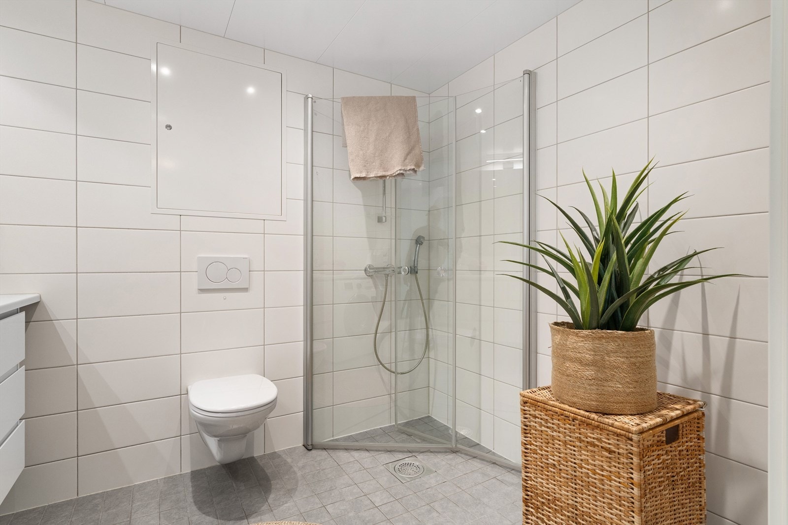 Videre har badet et vegghengt toalett, mekanisk avtrekk, opplegg for vaskemaskin og et dusjhjørne med innfellbare glassdører. Galleribilde