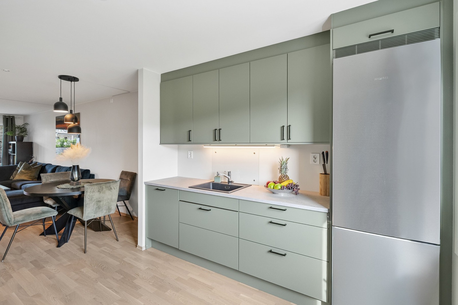 Innredningen har integrerte hvitevarer, herunder oppvaskmaskin, platetopp og stekeovn samt nisje for kjøl/fryseskap Galleribilde