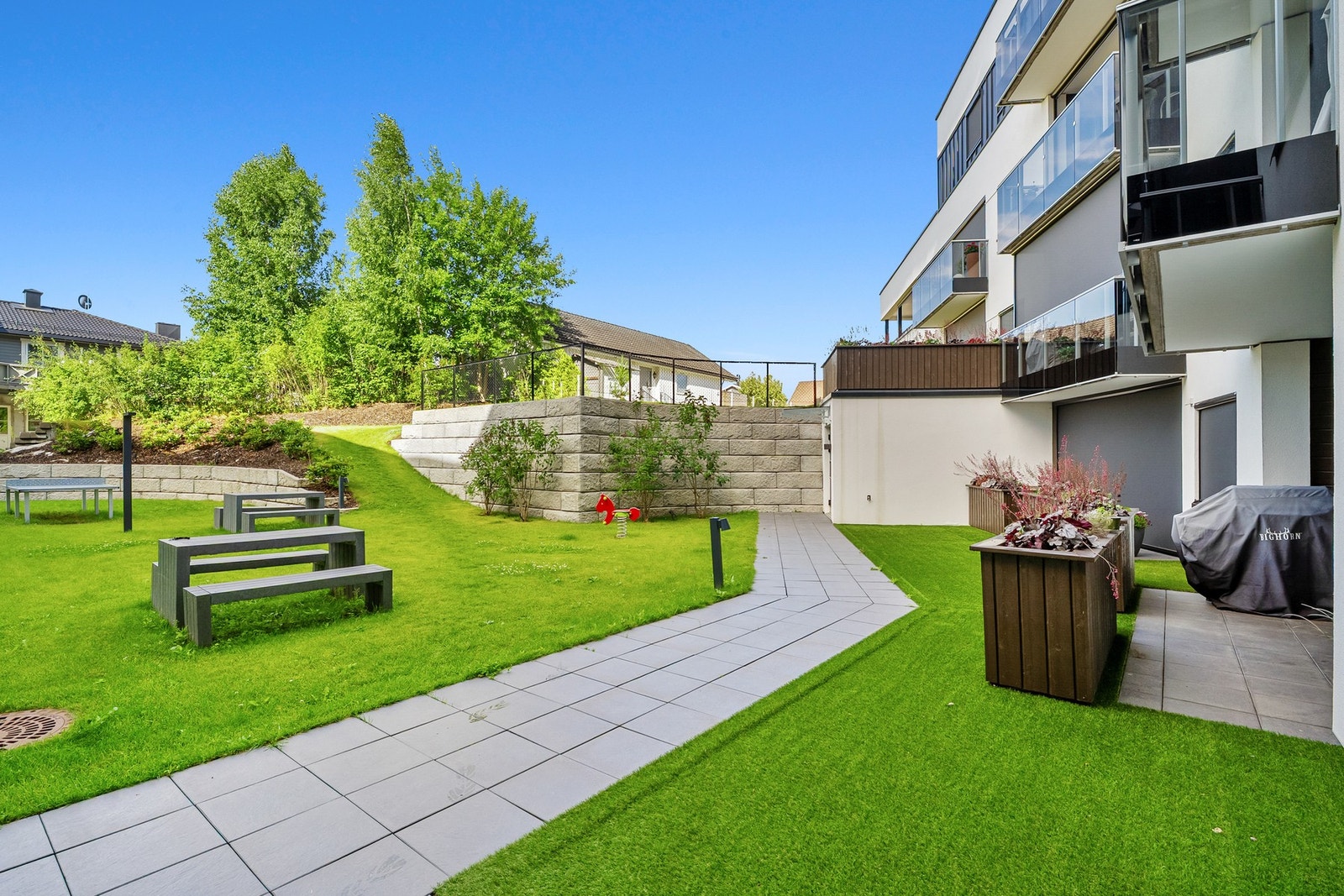 Hyggelig utsyn over pent opparbeidet fellesområde Galleribilde