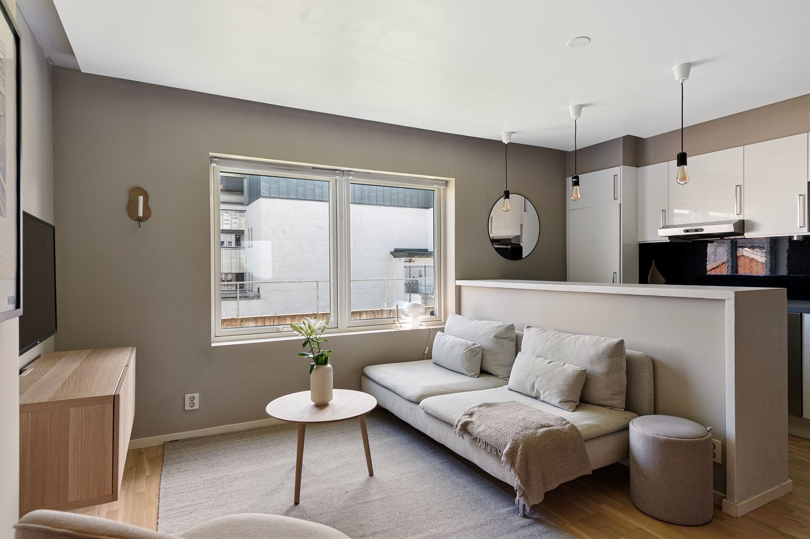 Praktisk kjøkkenøy i malt betong deler opp rommet på en fin måte. Galleribilde