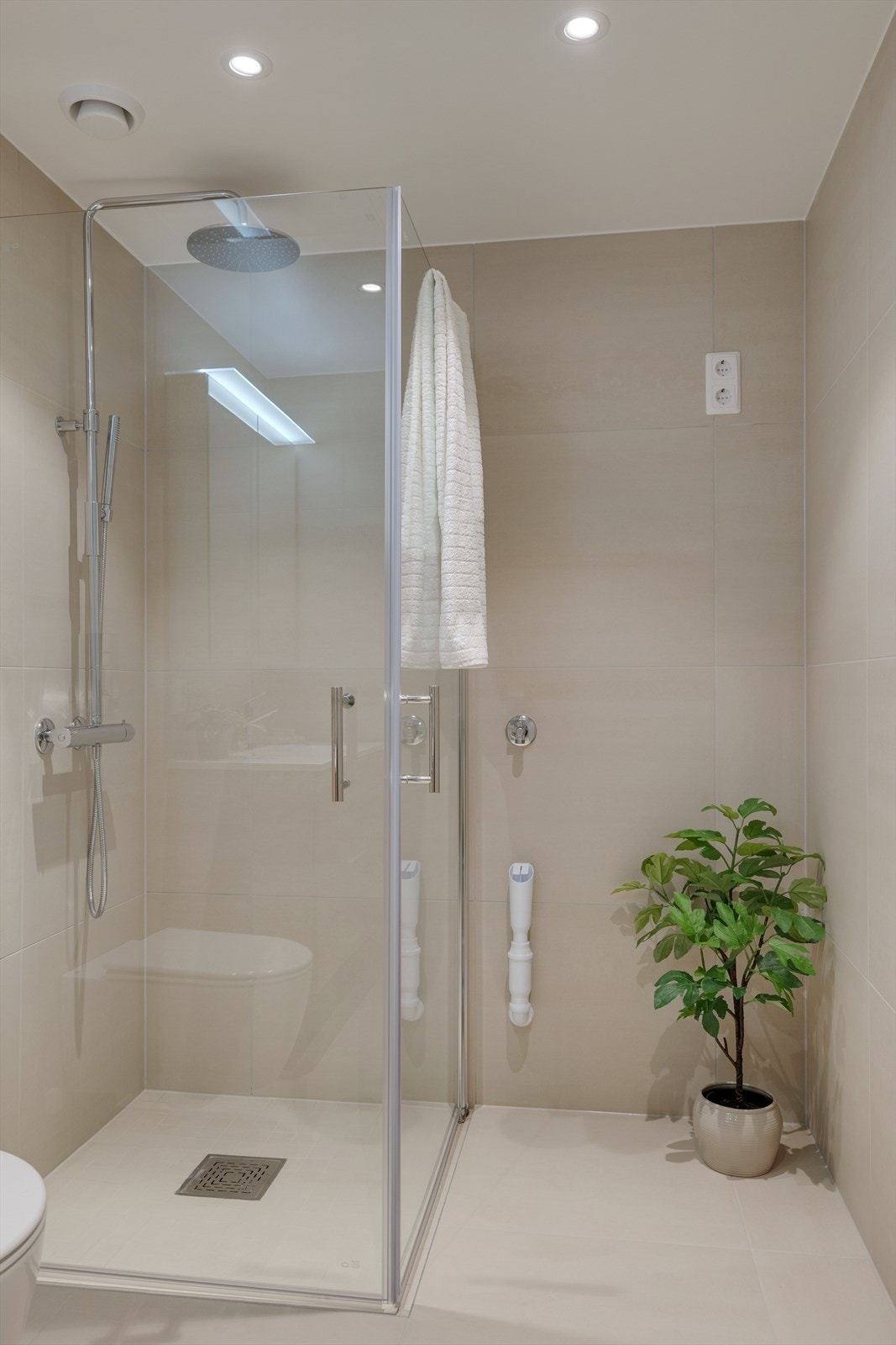 Dusjhjørne er utstyrt med dører i herdet glass i størrelse 90x90 og regnfallsdusj fra Tapwell. Det er avsatt plass og opplegg til vaskemaskin/kondenstørketrommel. Vannbåren varme i gulv samt LED downlights i nedsenket himling Galleribilde