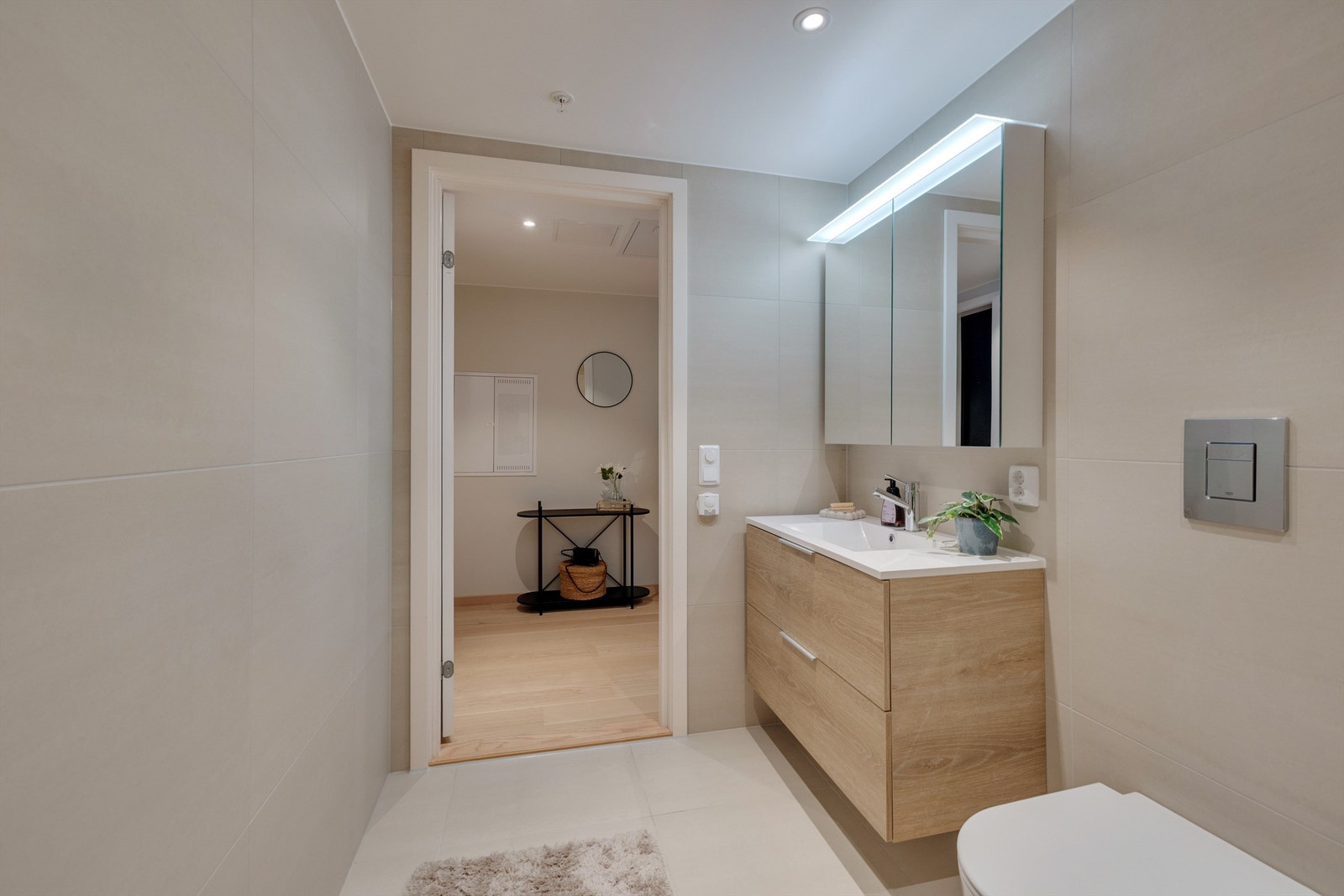 Baderomsinnredning fra Foss bad type Variant Natur servant square med doble skuffer og heldekkende vask. Speilskap i samme bredde som underskapene leveres med lys og stikk-kontakt. Vegghengt toalett fra Villeroy & Boch og Grohe trykkplate Galleribilde