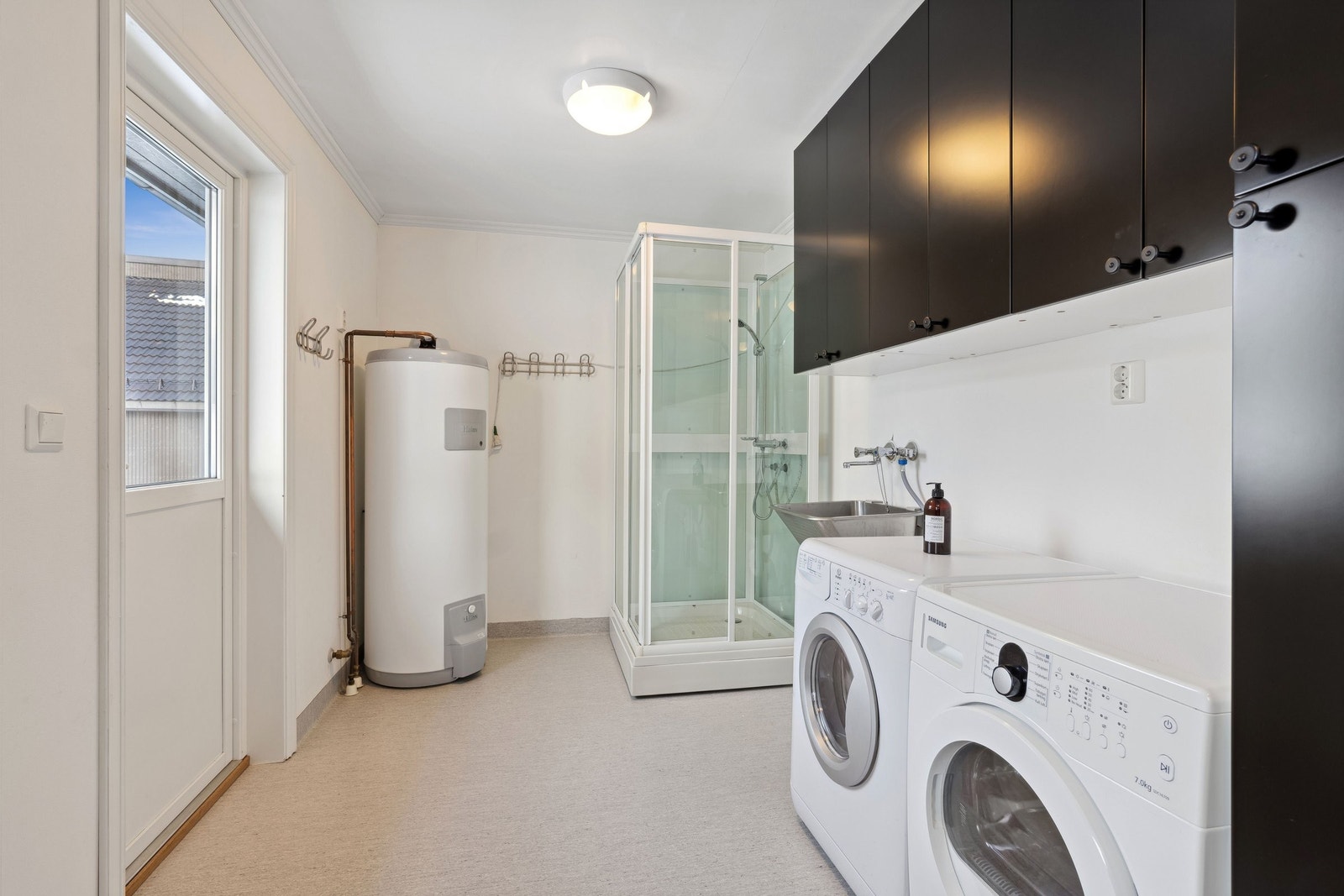 Vaskerom i hoved etasjen. Med dusj og lagringsplass. Det er også utgang til hagen og liten terrasse. Galleribilde