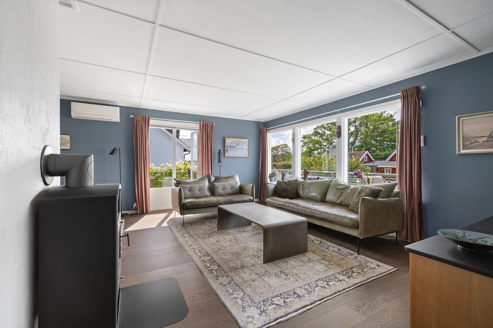 En romslig stue med store vindusflater for mye naturlig lys. Galleribilde