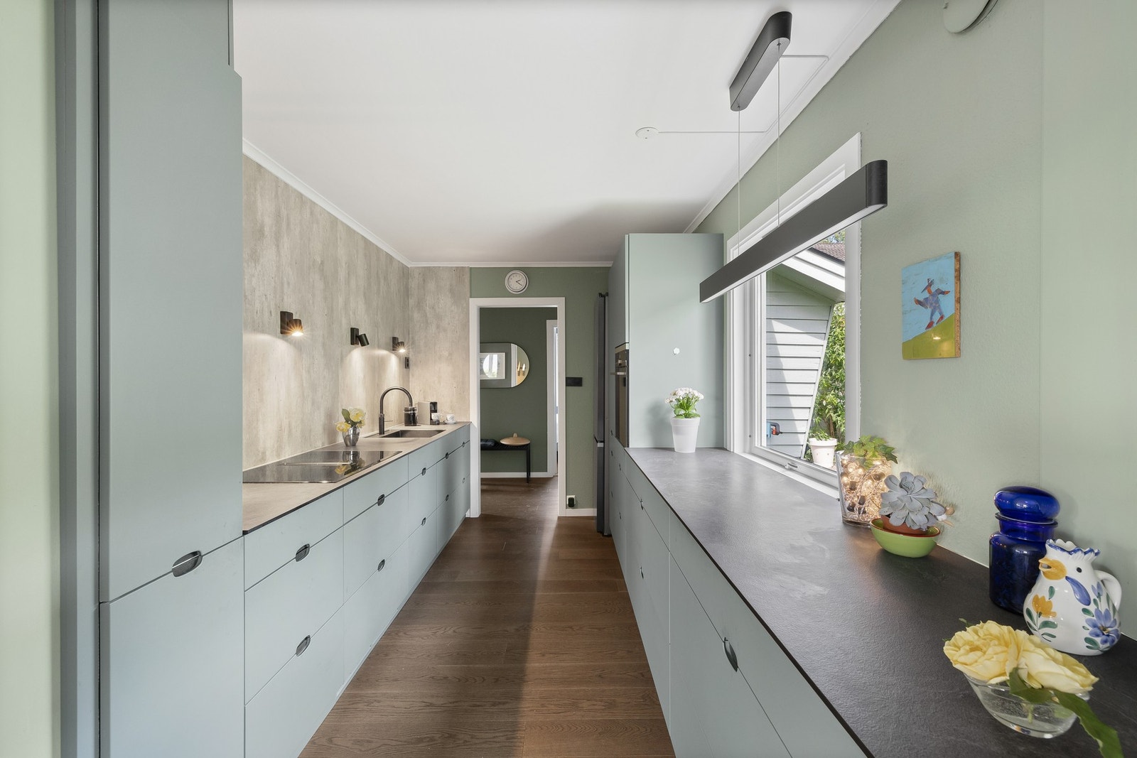 Kjøkkenet har stilren, moderne innredning fra 2021 med grønne, glatte fronter, kompositt benkeplater og underlimt oppvaskkum. Galleribilde