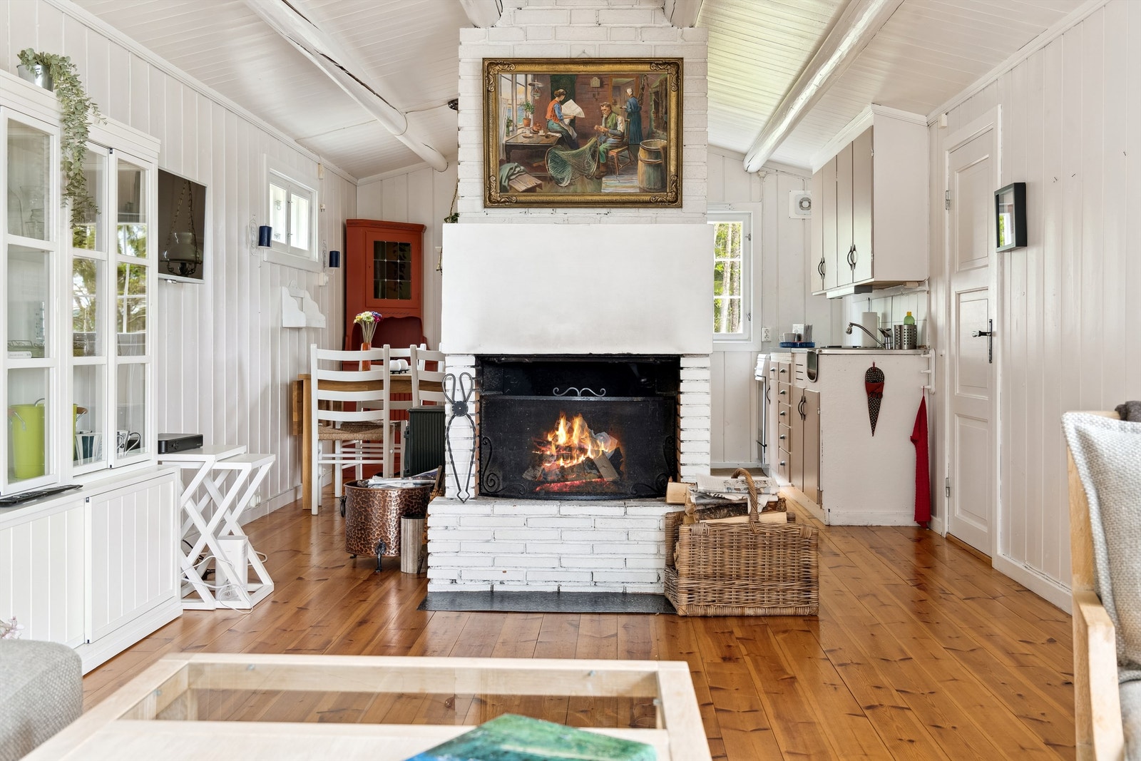Kjøkkenet er avskjermet fra stuen av den oppmurte peisen Galleribilde