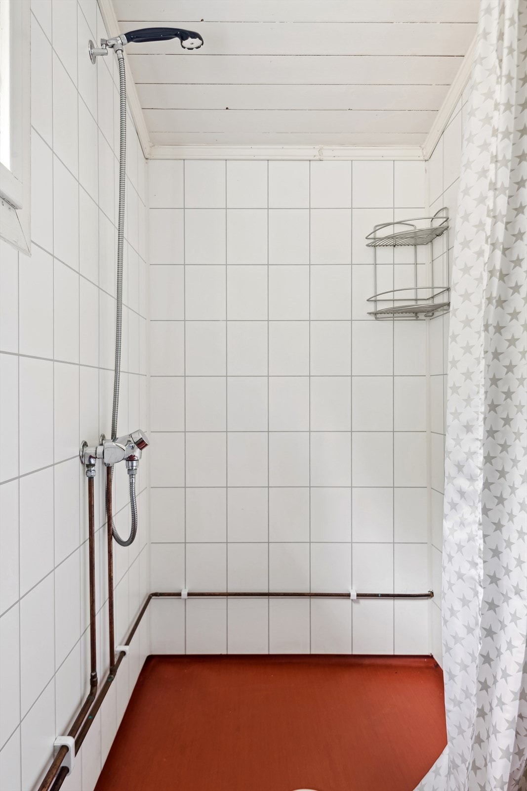 I den neste delen er det dusjhjørne med forheng og armatur montert på veggen. Panelovn montert som varmekilde på første delen av badet. Badet ventileres via naturlig ventilasjon via veggventil. Galleribilde