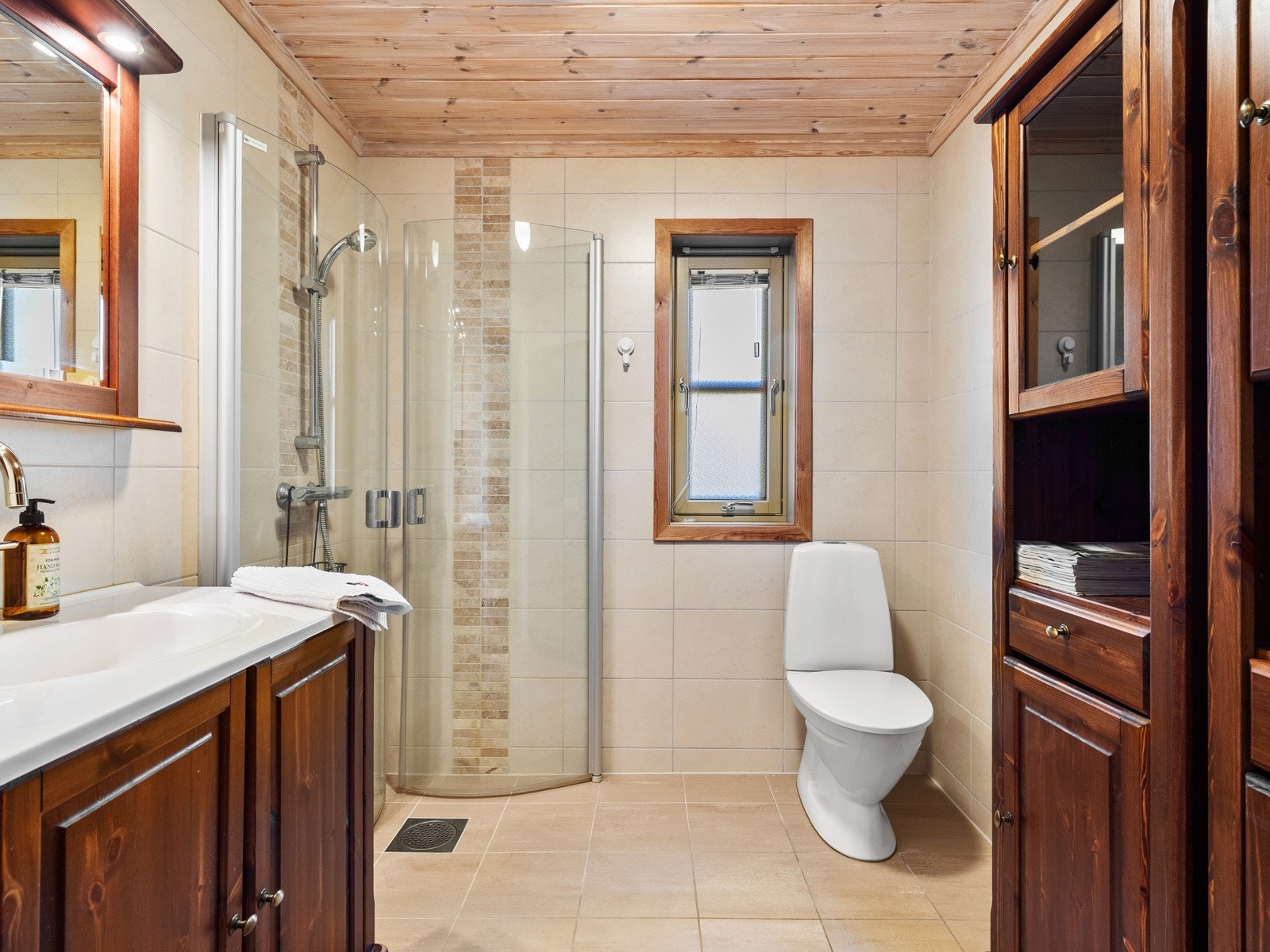 Flislagt baderom med dusjhjørne og toalett. Galleribilde