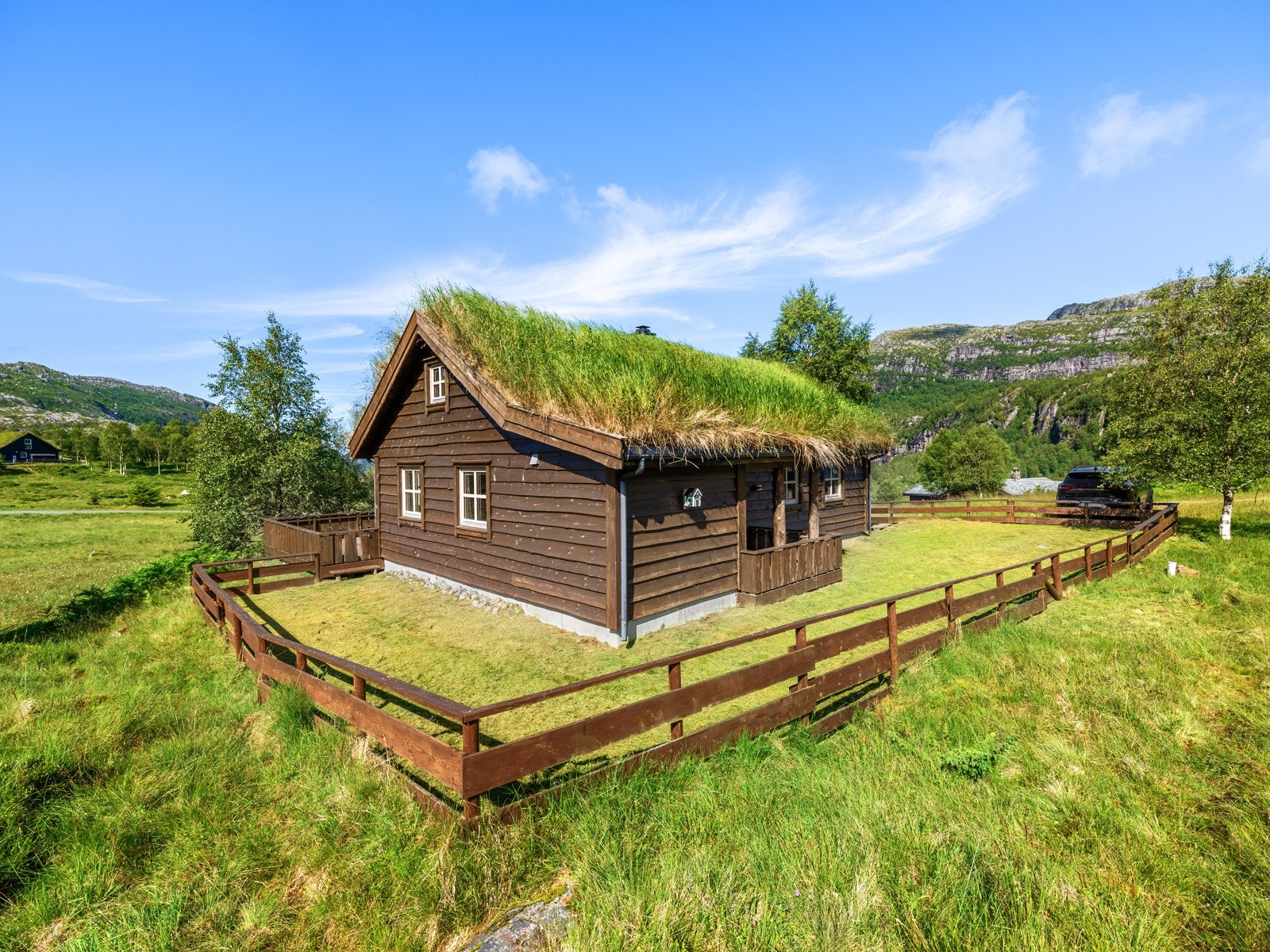 Pen klassisk stil med saltak i torv, brunbeiset villmarkskledning og vinduer med sprosser. Galleribilde