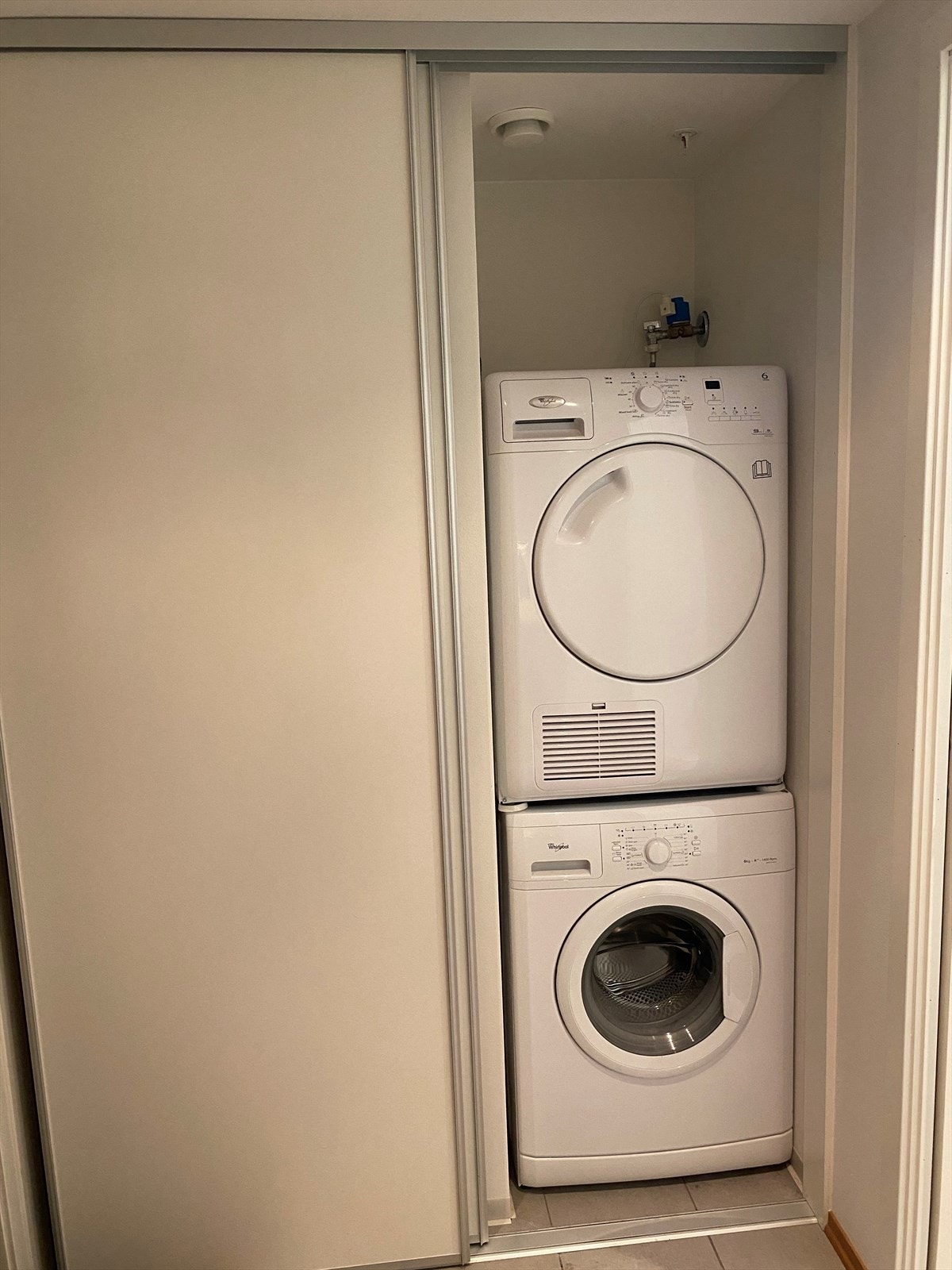 Smart og plassbesparende løsning med vaskemaskin og tørketrommel gjemt i skyvedørsgarderoben i entrèen. Galleribilde