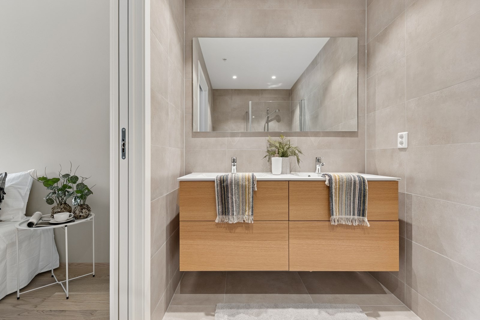 Lys baderomsinnredning med dobbelvask, ekstra skuffeplass, dusj og toalett. Galleribilde