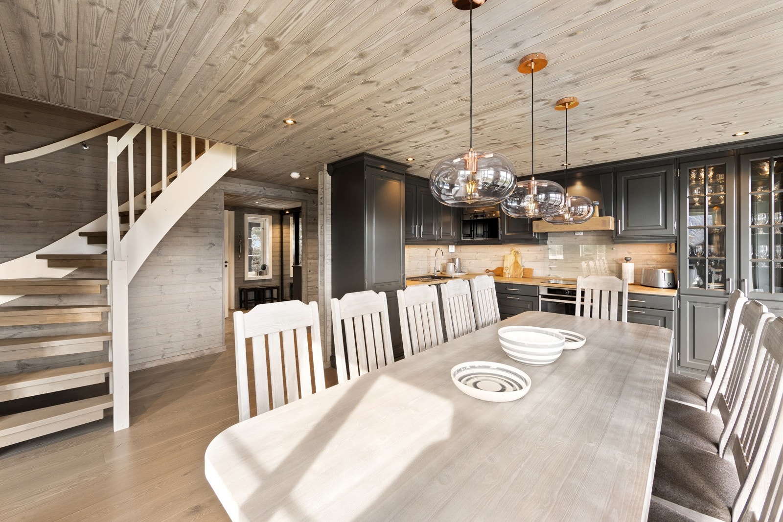 Flott kjøkken med innredning av tre på to vegger med malte profilerte fronter. Galleribilde