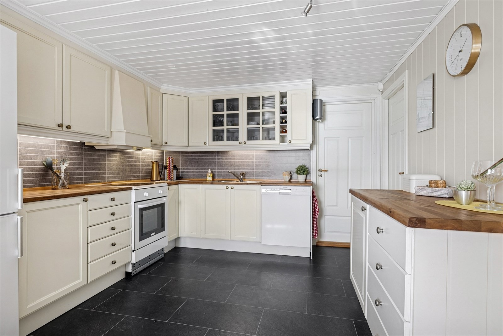 Kjøkkeninnredningen er med profilerte fronter og heltre benkeplate Galleribilde