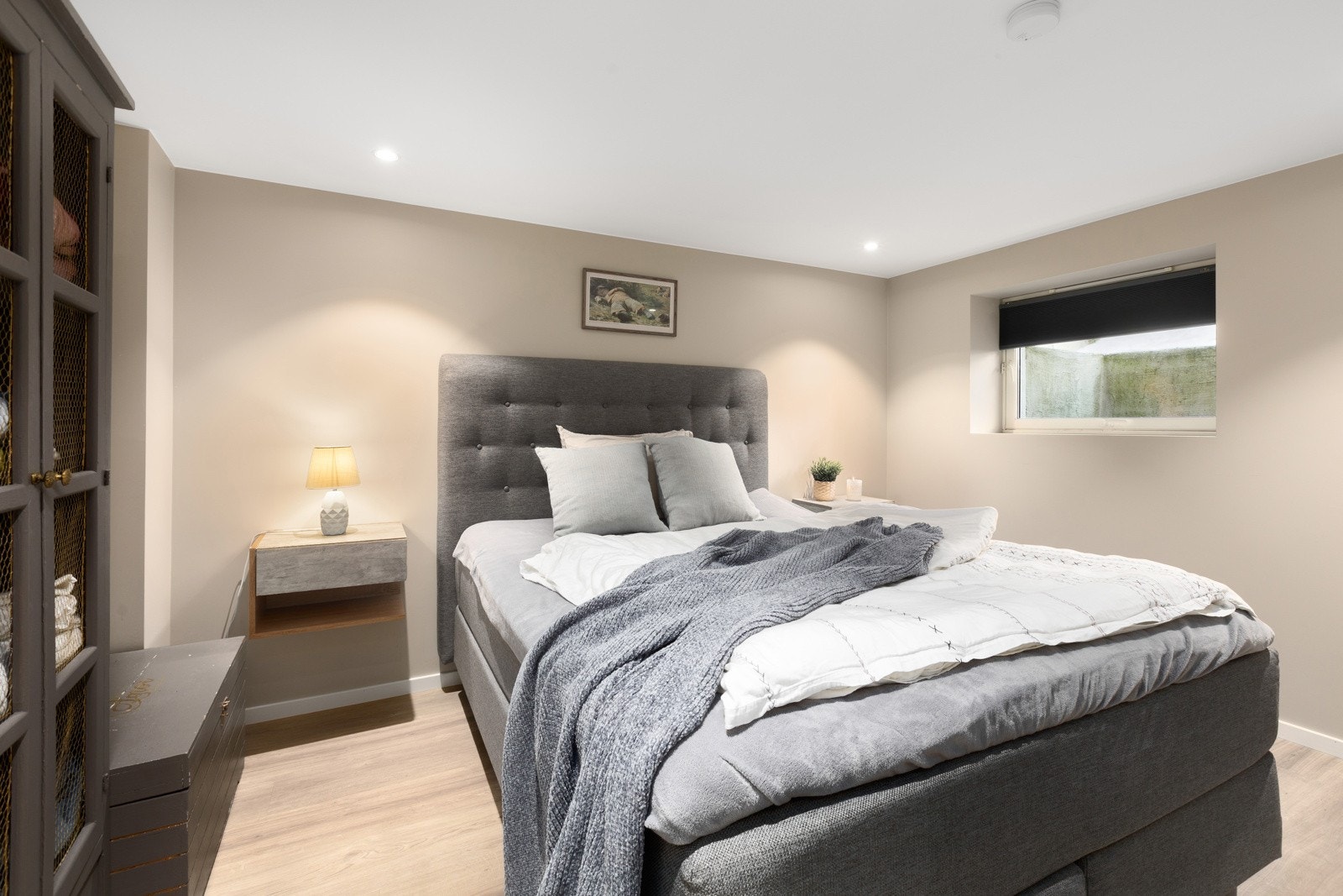 Soverom underetasjen med 1-stavs laminatgulv, malte flater på vegg og gips med downlights i tak. Galleribilde