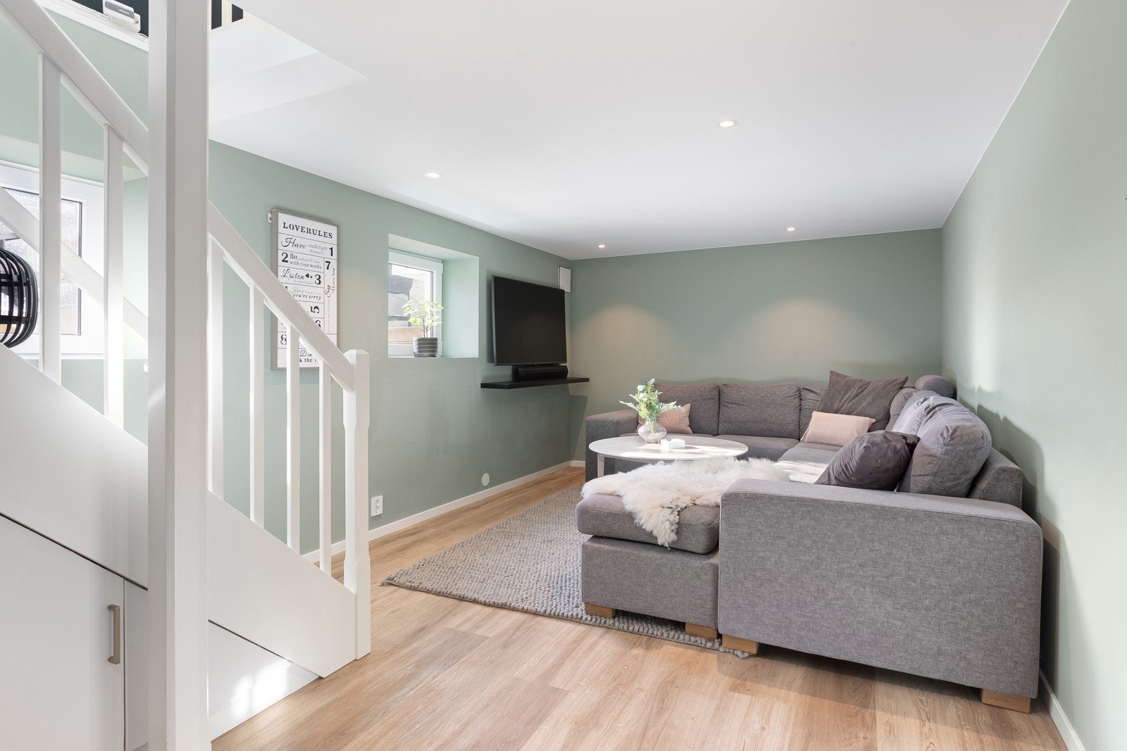 Kjellerstue med 1-stavs laminatgulv, malte flater og gips i tak med downlights. Galleribilde