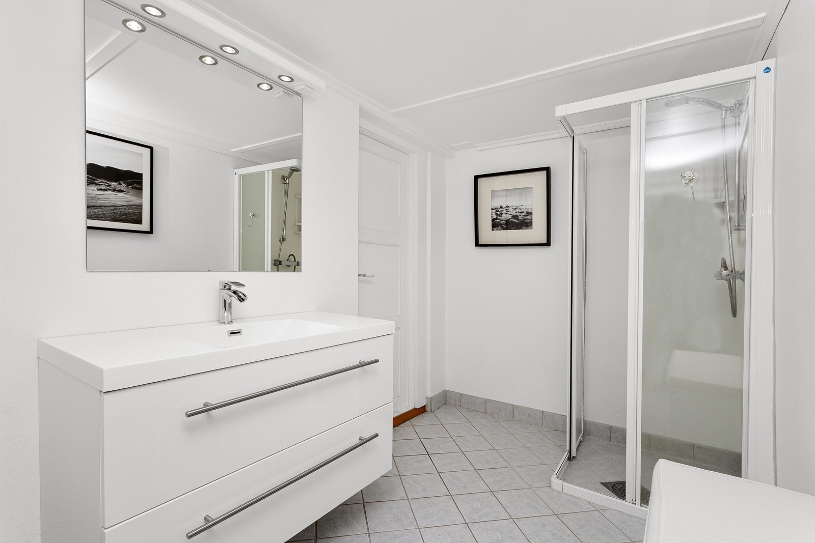 På bad i kjeller er det innredet med innredning med heldekkende servant, speil, toalett og hjørnedusj med glassdører. Galleribilde