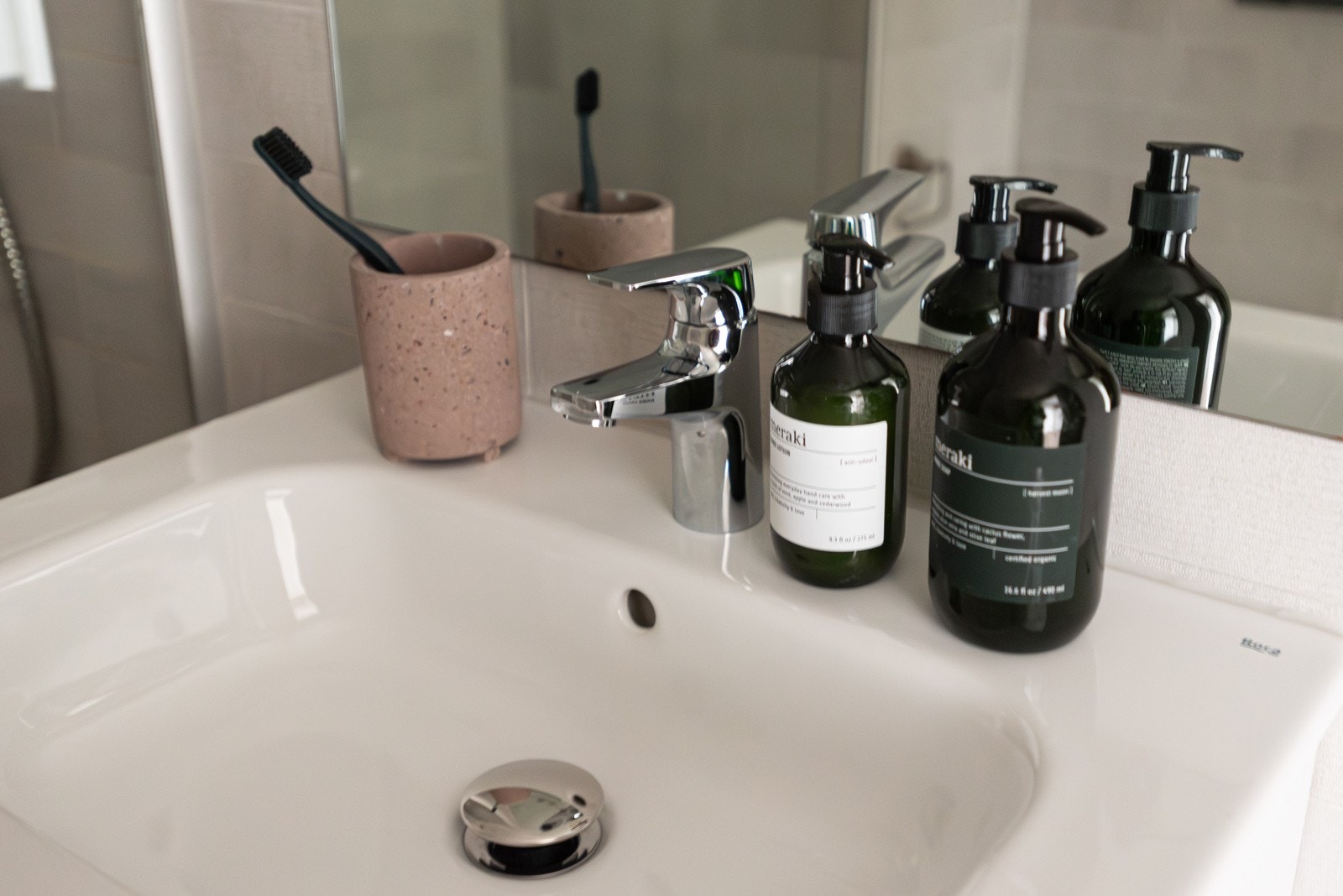 Badet er innredet med servant med innredning, speil, dusjhjørne med glassvegg, vegghengt toalett og opplegg for vaskemaskin. Galleribilde