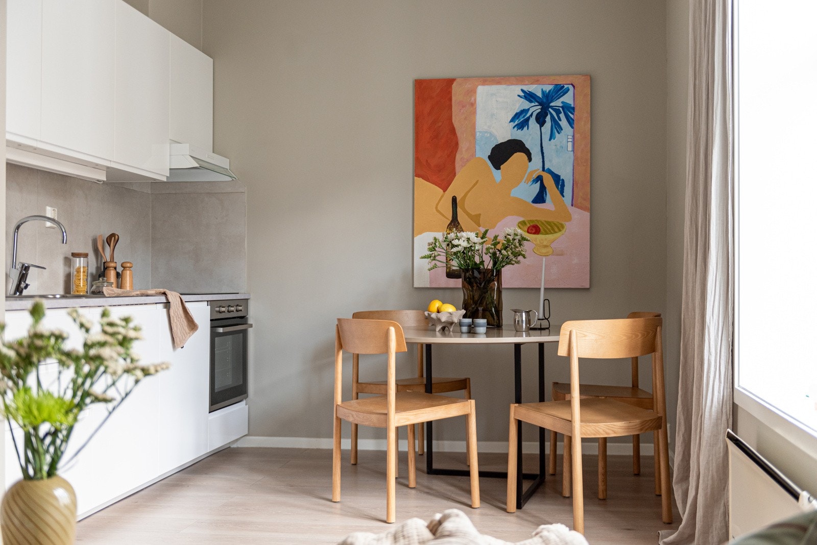 Åpen kjøkkenløsning med tidsriktig glatt innredning, soft close, fliser over benk og laminat benkeplate med nedfelt stålkum Galleribilde