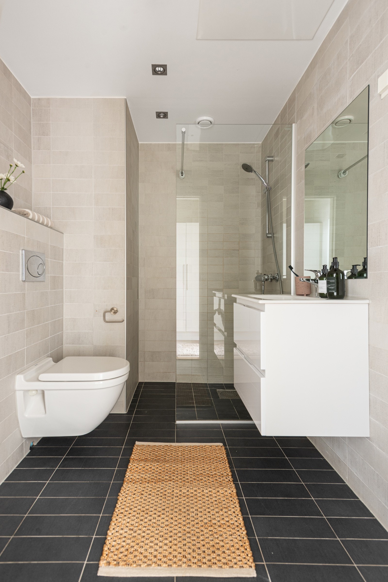 Pent flislagt baderom med varmekabler og downlights Galleribilde