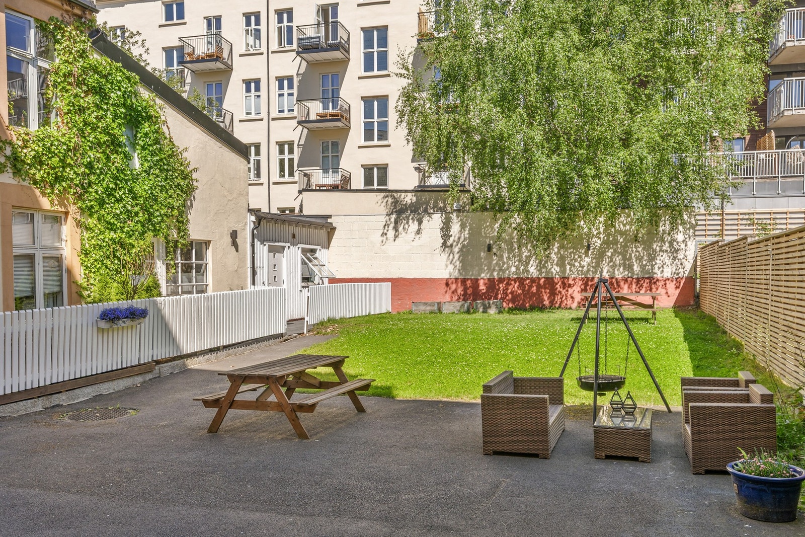 Solrik og pent opparbeidet bakgård med sittegrupper, gressplen og hyggelig atmosfære. Galleribilde