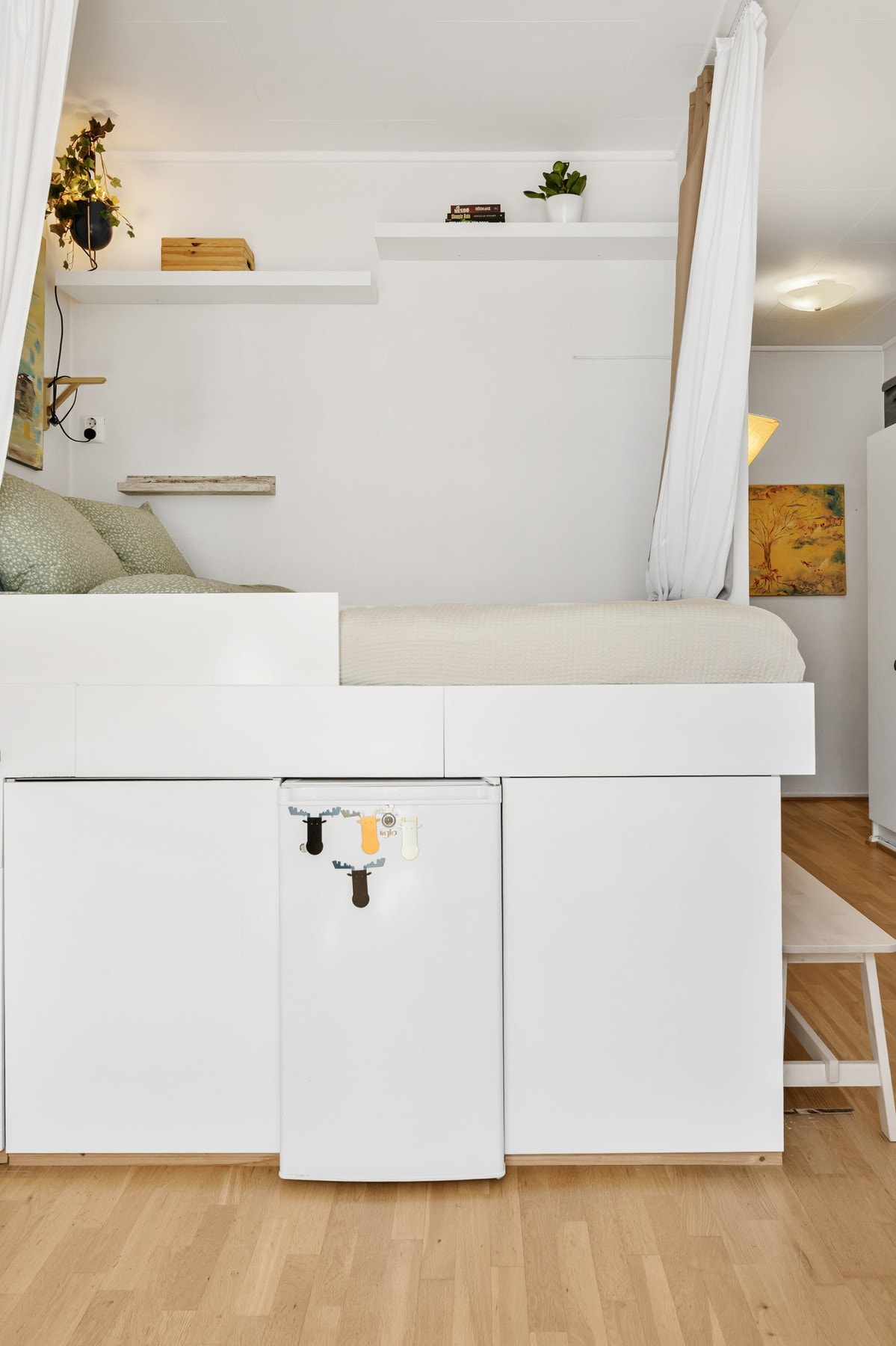 Plassbygget seng med praktisk oppbevaring under. Integrert kjøleskap og skap gir smart utnyttelse av arealet. Galleribilde