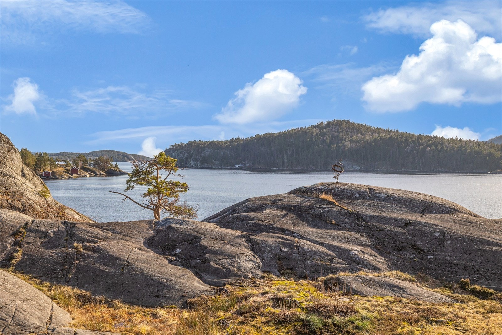 Mellom bebyggelsen er det noe gress blant fjell og naturlig vegetasjon. Galleribilde