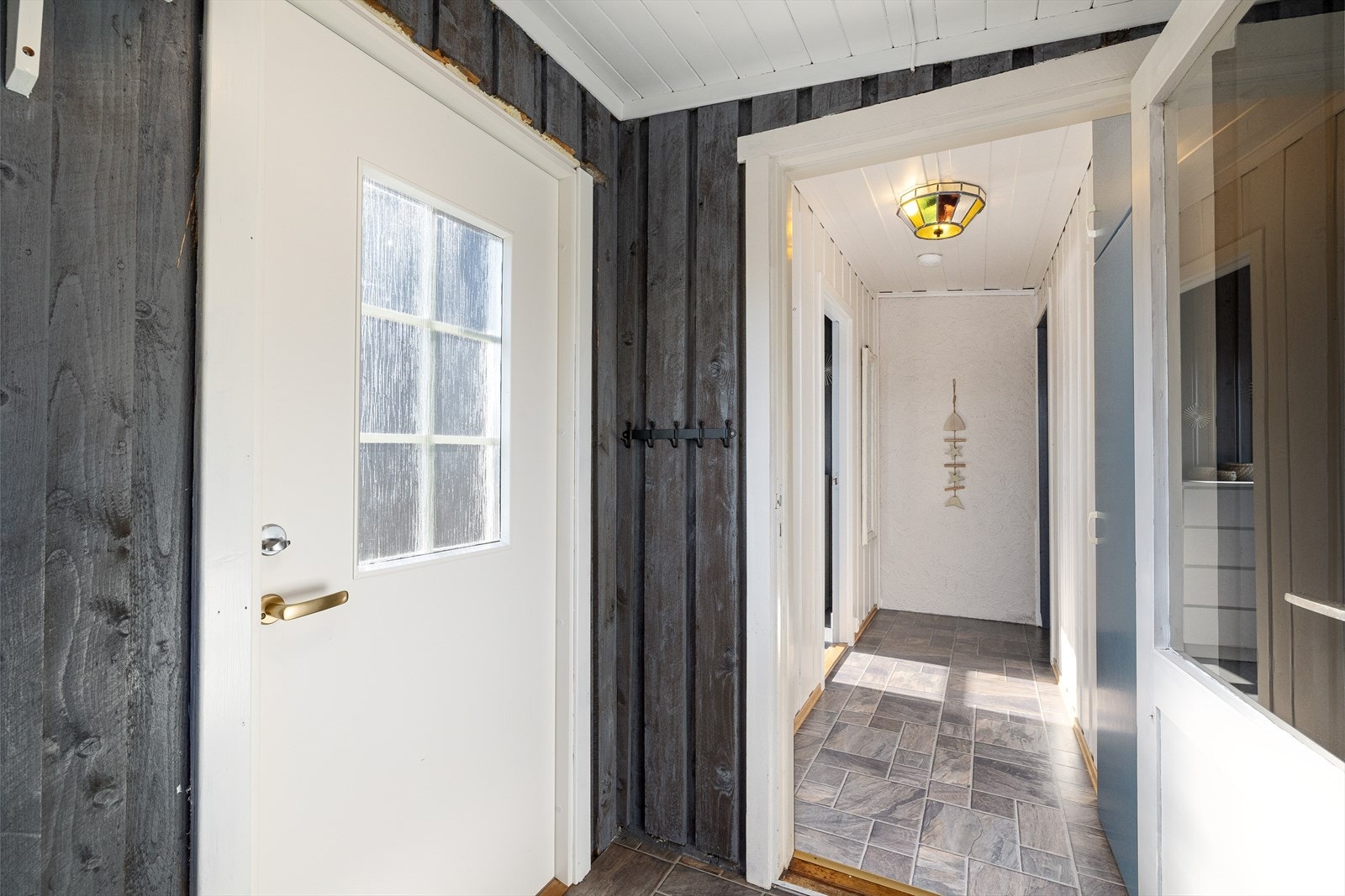 Ytterdøren var ny i 2023 og fører inn til entré med bod, og videre inn til en gang med plassbygd skap. Galleribilde