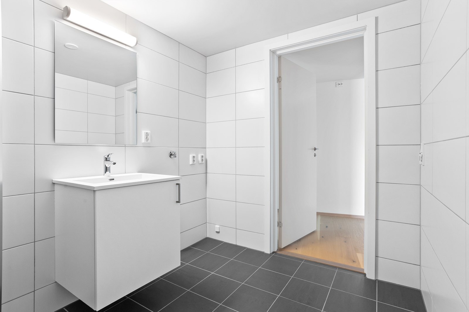 Baderomsinnredning med servant, underskap, dusjsone og vegghengt toalett. Galleribilde