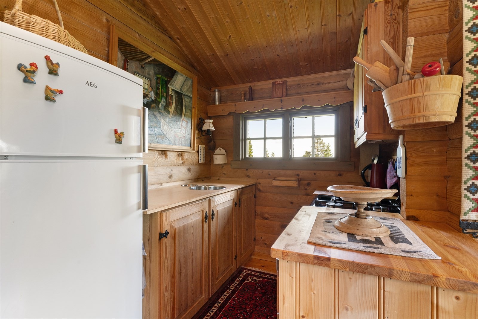 Kjøkkeninnredningen har profilerte fronter, laminert og heltre benkeplate, utslagsvask i stål, gass komfyr, kjøl/frys. Det er ingen ventilering fra kjøkken. Galleribilde