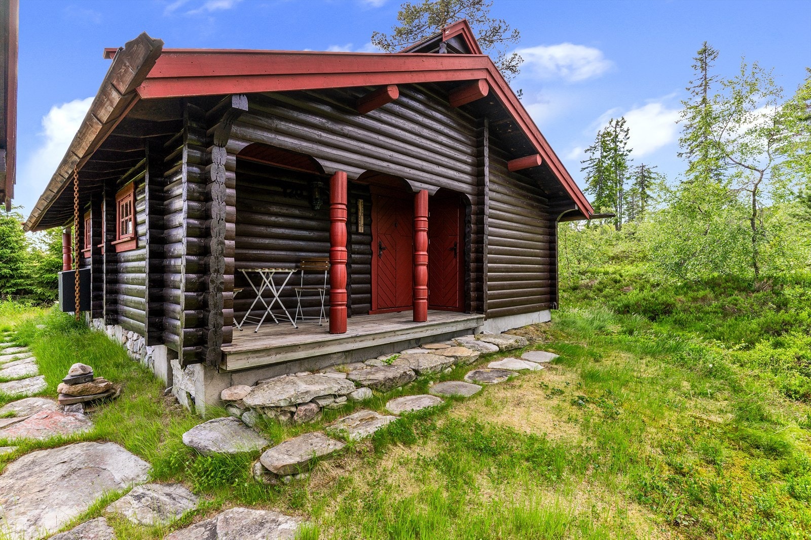 Hytta har en lett skrånet naturtomt. Galleribilde